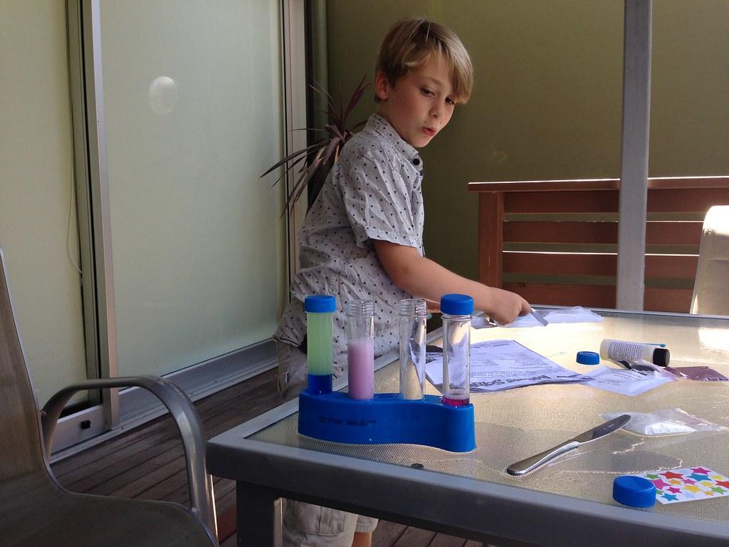 chłopiec przeprowadzający chemiczny eksperyment z zestawem małego chemika