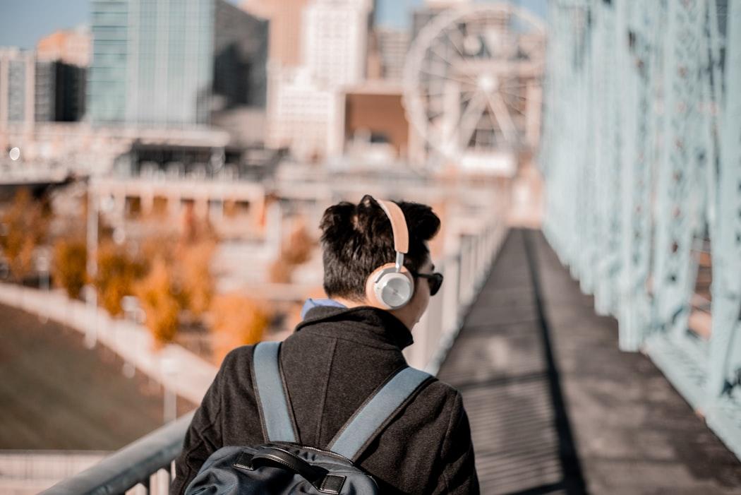 Chłopak słuchający muzyki lub podcastu przez słuchawki