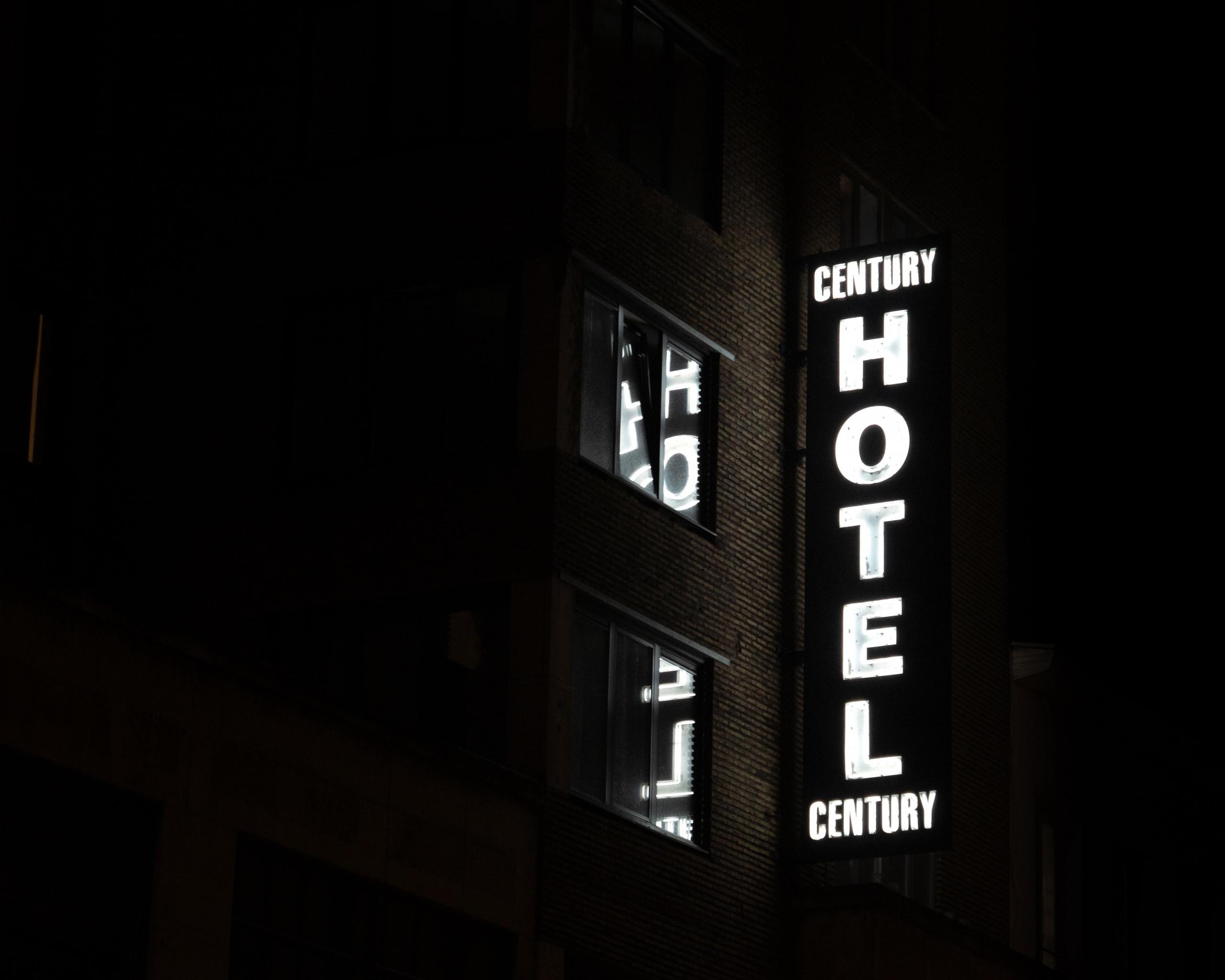 Neon z napisem hotel century świecący w nocy.