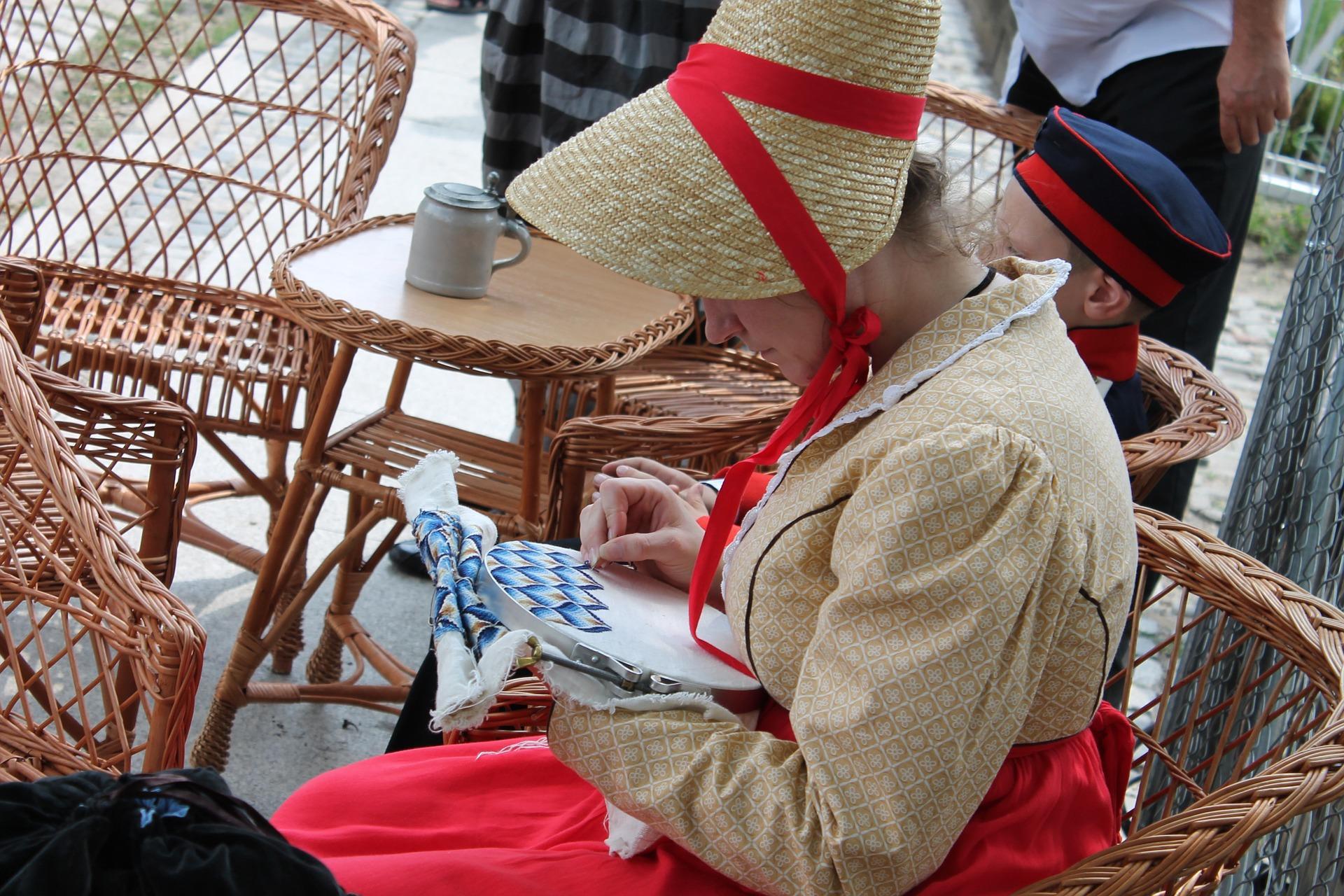 tradycyjnie ubrana haftująca kobieta