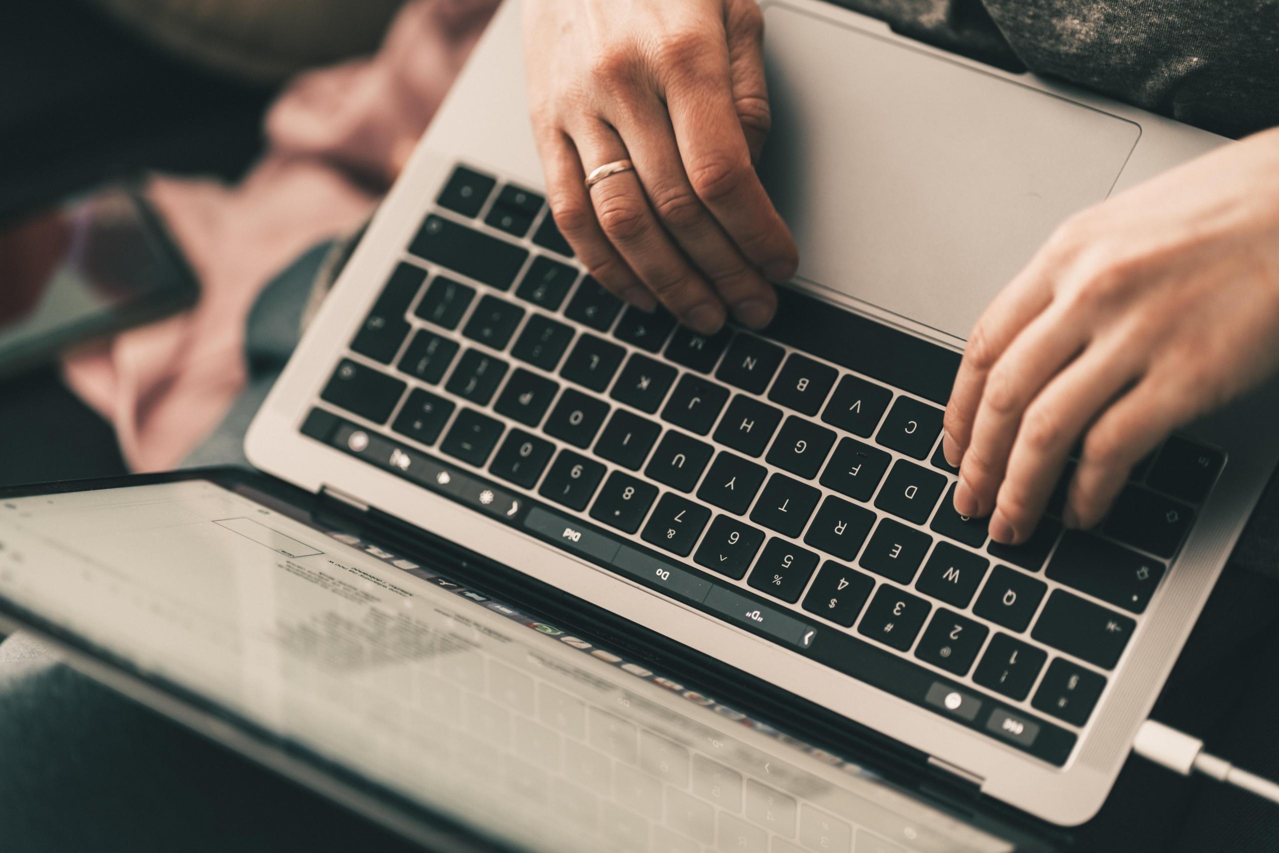 Osoba pracująca przy laptopie.