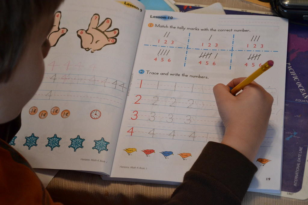 chłopiec wykonujący ćwiczenia w podręczniku do matematyki
