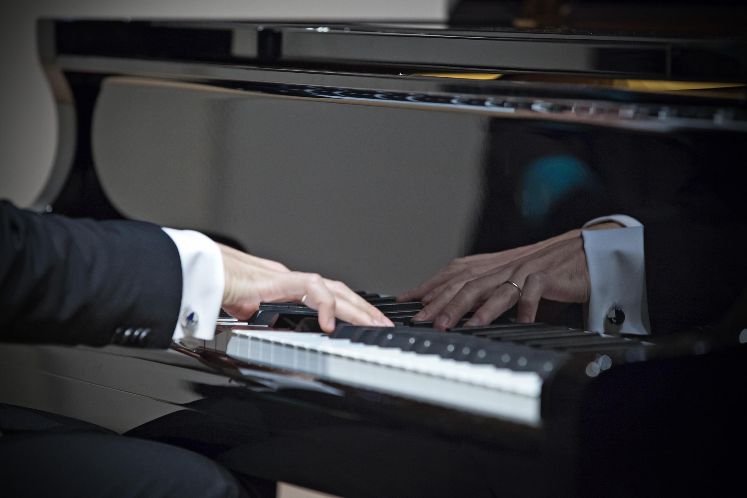 Dłoń pianisty przy fortepianie.