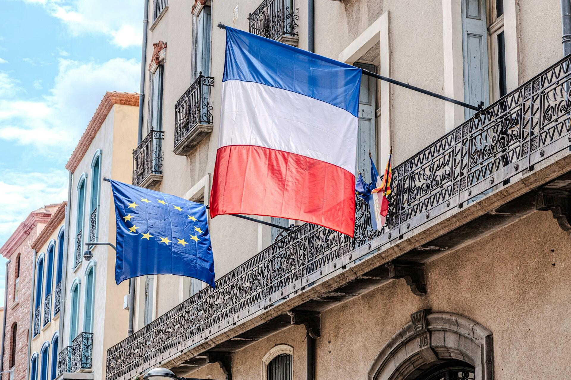 Flagi Francji i Unii Europejskiej na budynku.