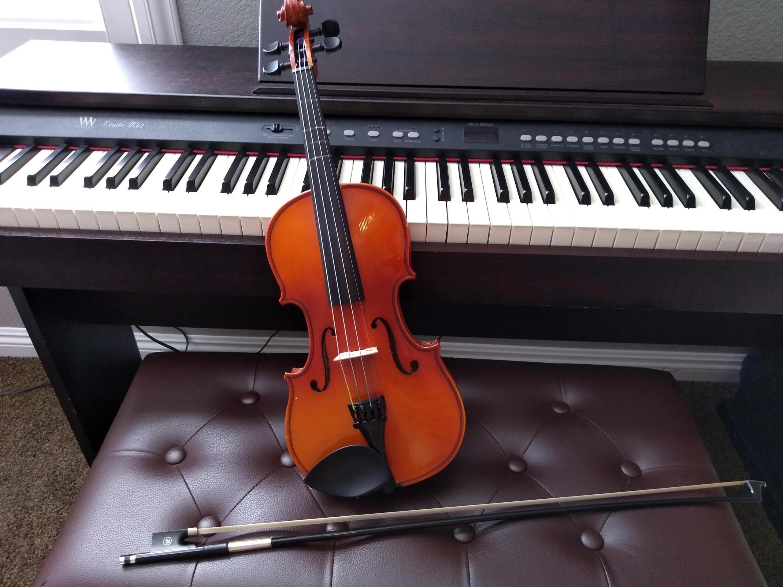 Skrzypce, smyczek, ława i instrument klawiszowy.