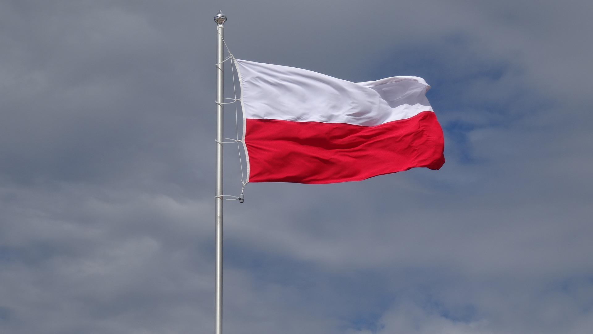 polska flaga powiewająca na maszcie na tle pochmurnego nieba