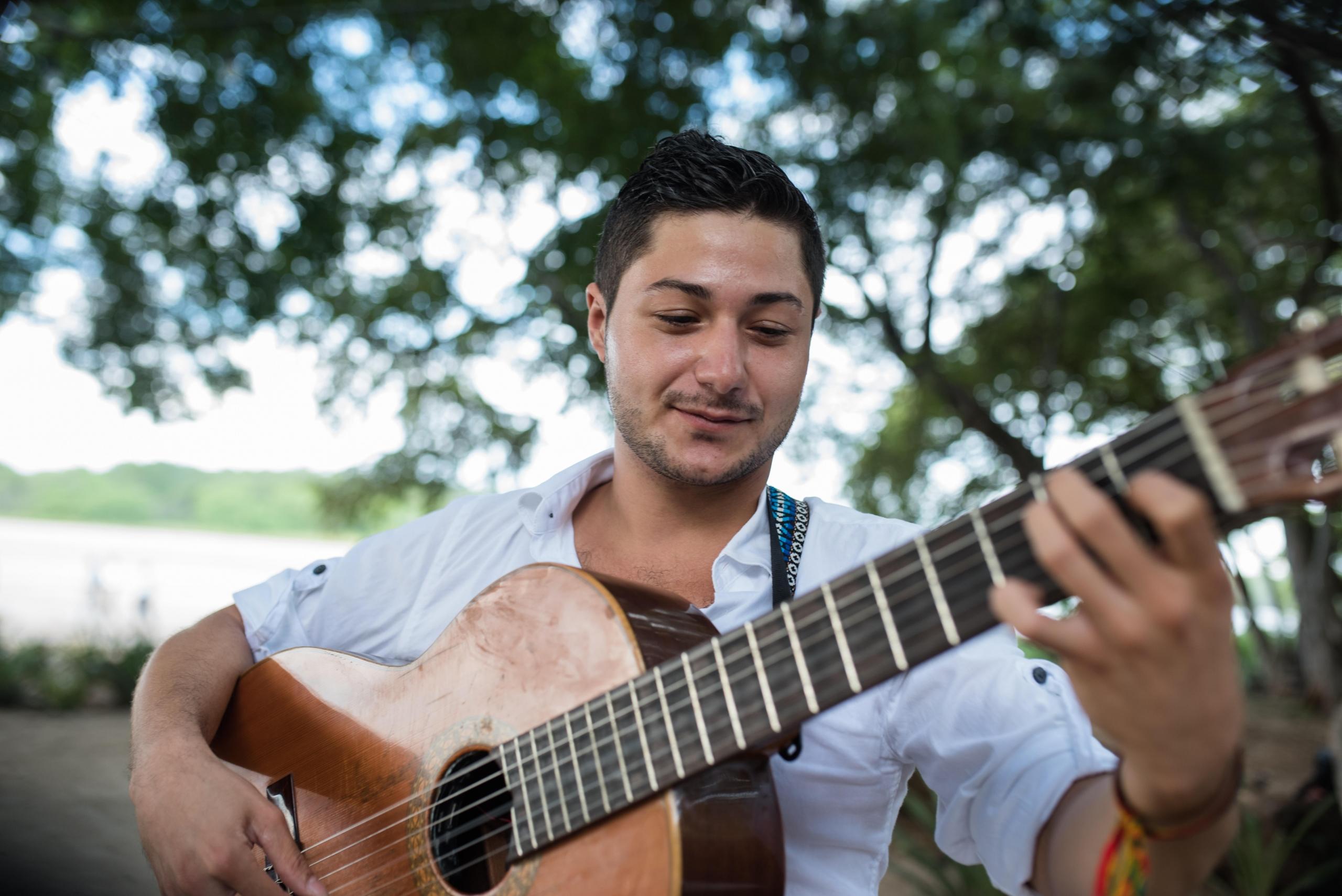 Mężczyzna zadowolony z zalet gry na gitarze.
