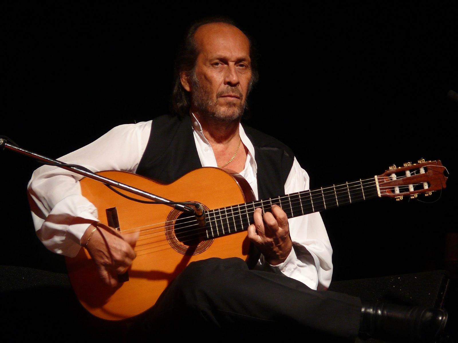 Paco de Lucia z gitarą przy mikrofonie, gitarzysta światowej sławy.