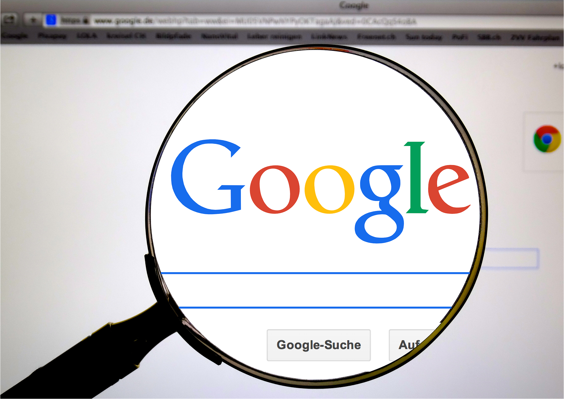 lupa przystawiona do monitora z włączoną wyszukiwarką google