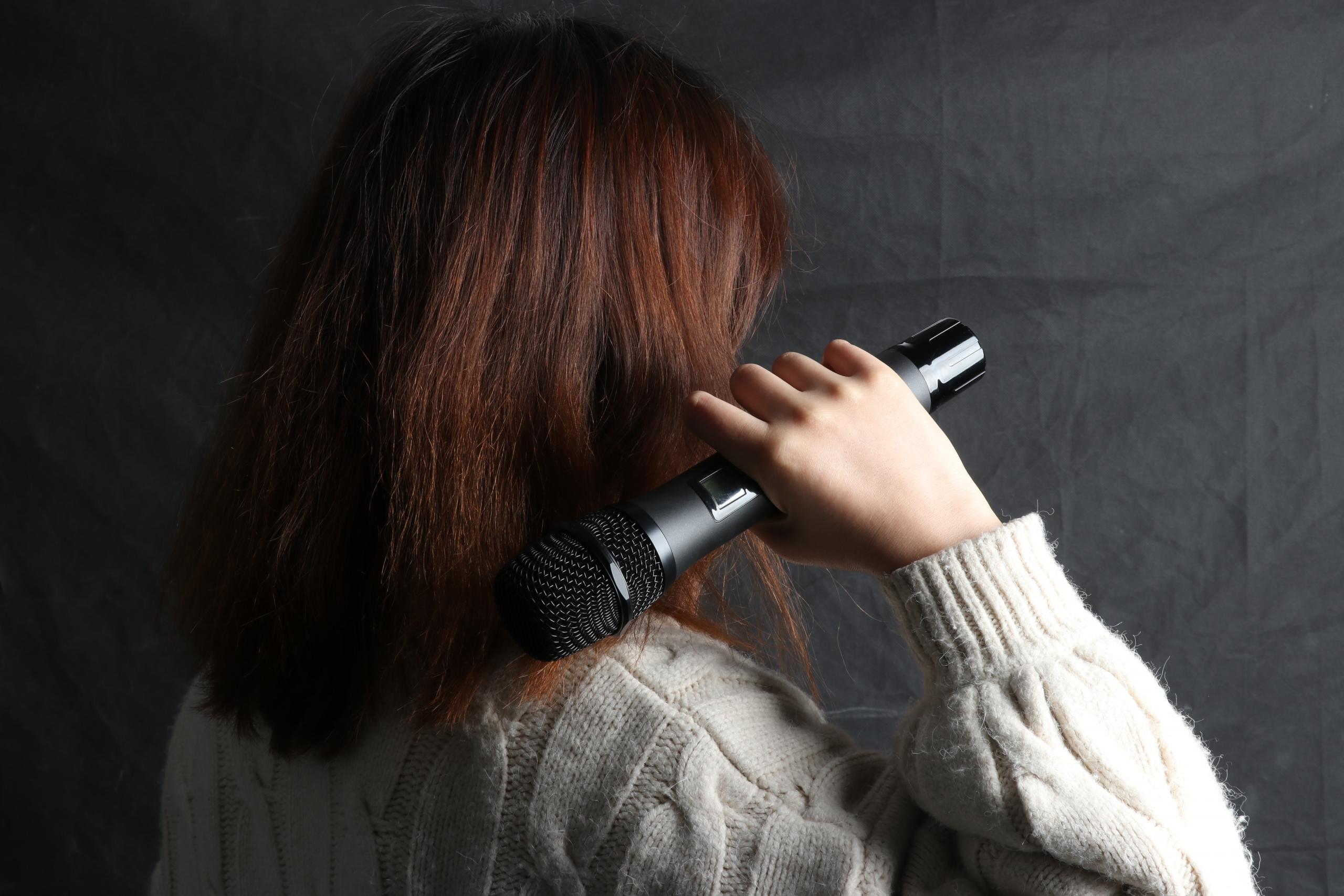 Nauka śpiewu w domu, kobieta z mikrofonem.