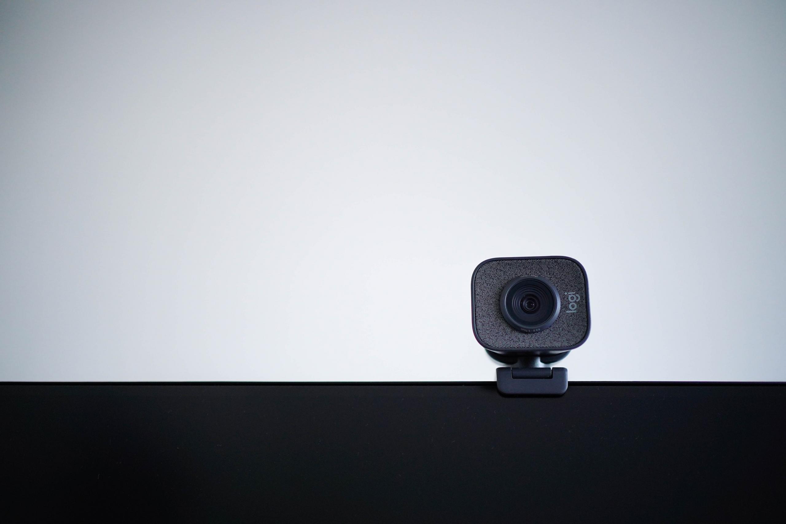 kamera internetowa przyczepiona do monitora na tle białej ściany