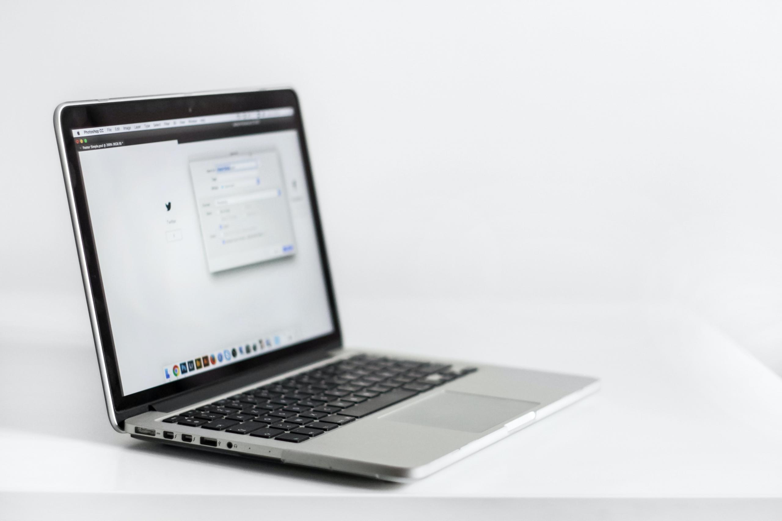 włączony laptop na białym tle