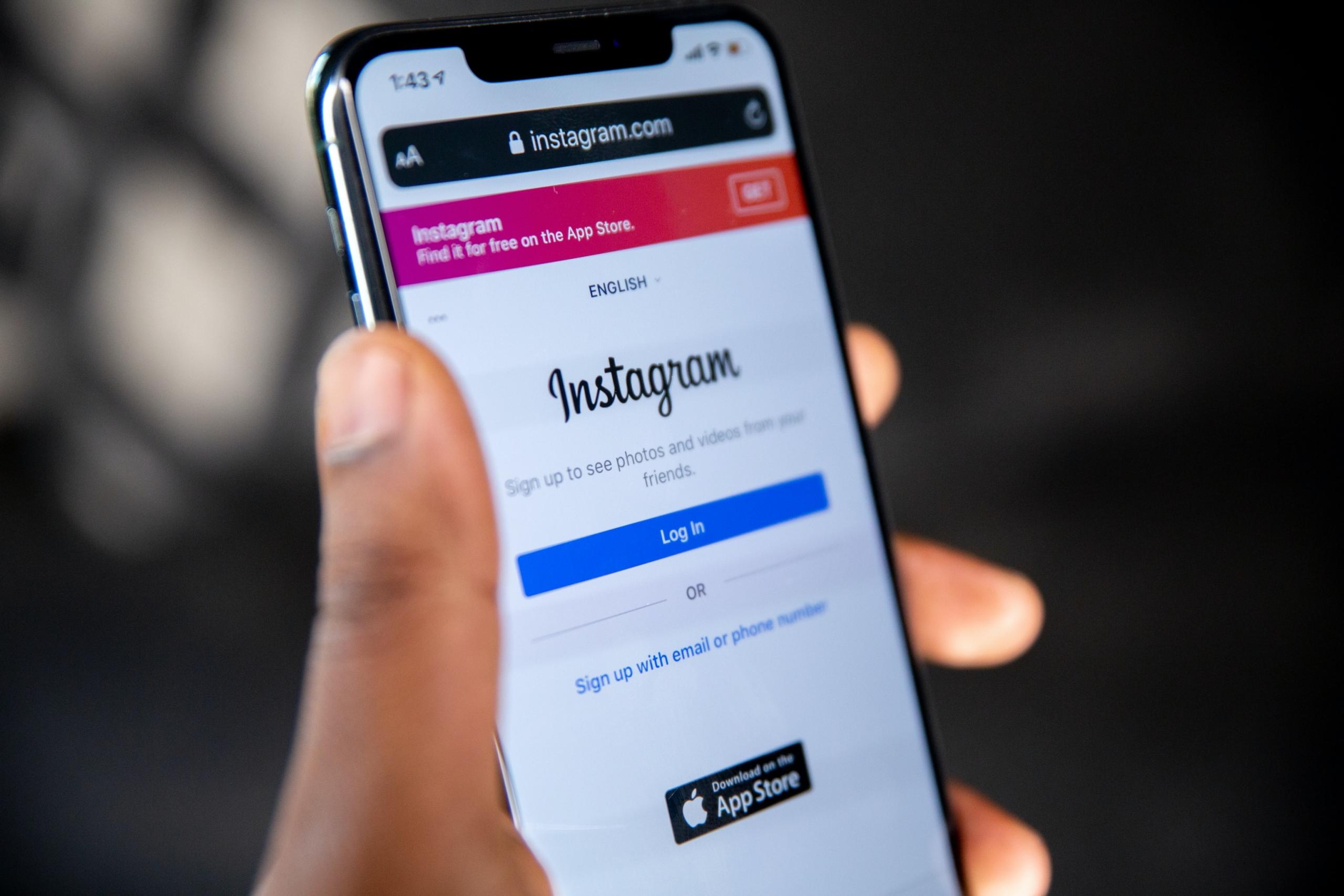 strona logowania w aplikacji instagram otwarta na smartwonie który jjest trzymany przez osobę