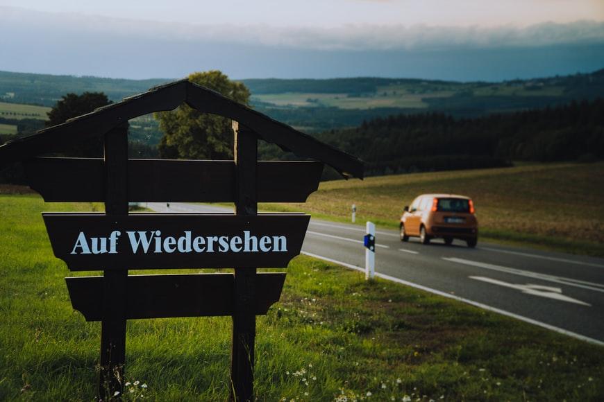 Niemiecki znak na drodze Auf Wiedersehen mijany przez auto