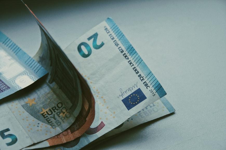 Pięć banknotów w euro leżące na białym stole