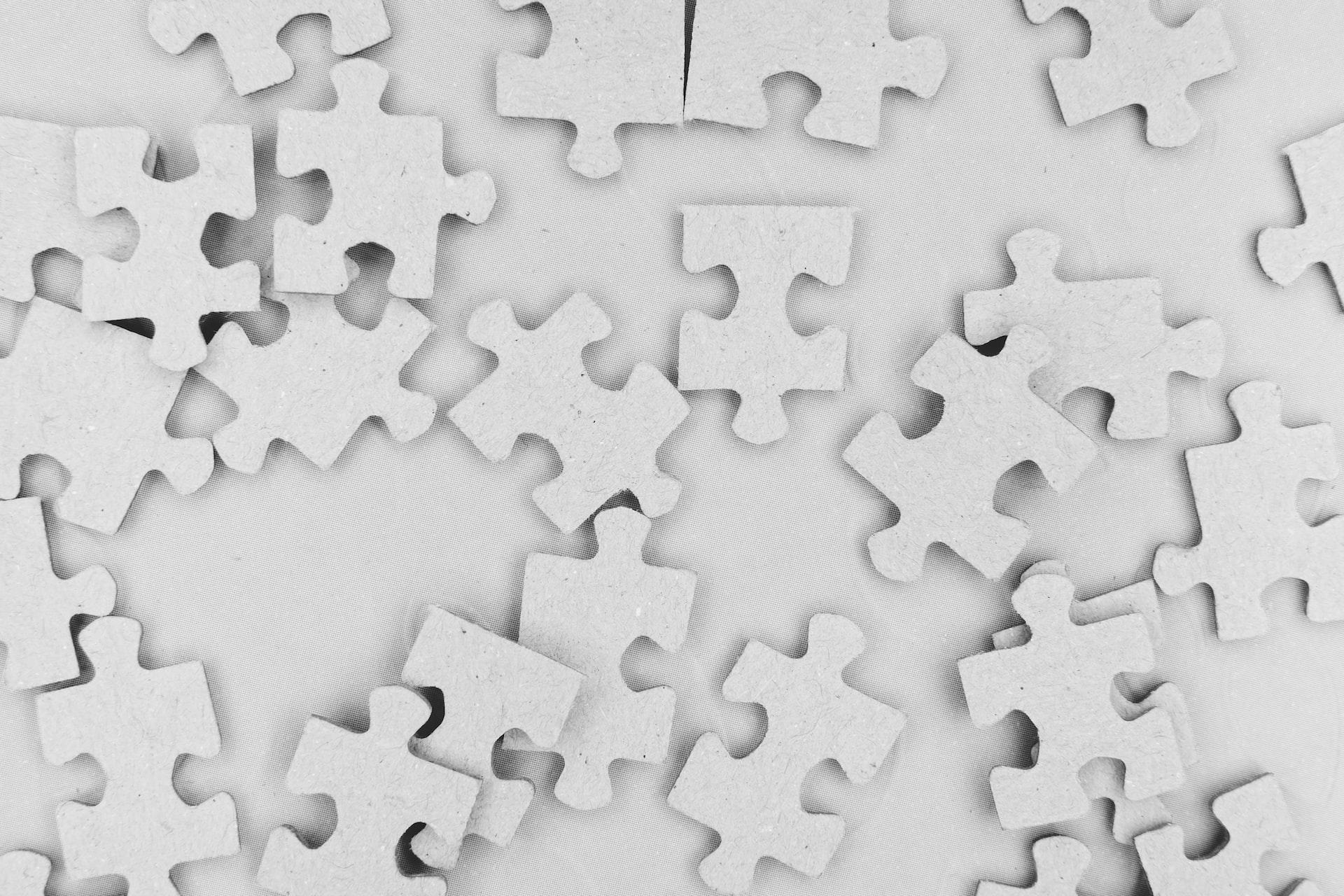białe puzzle rozsypane na białym tle