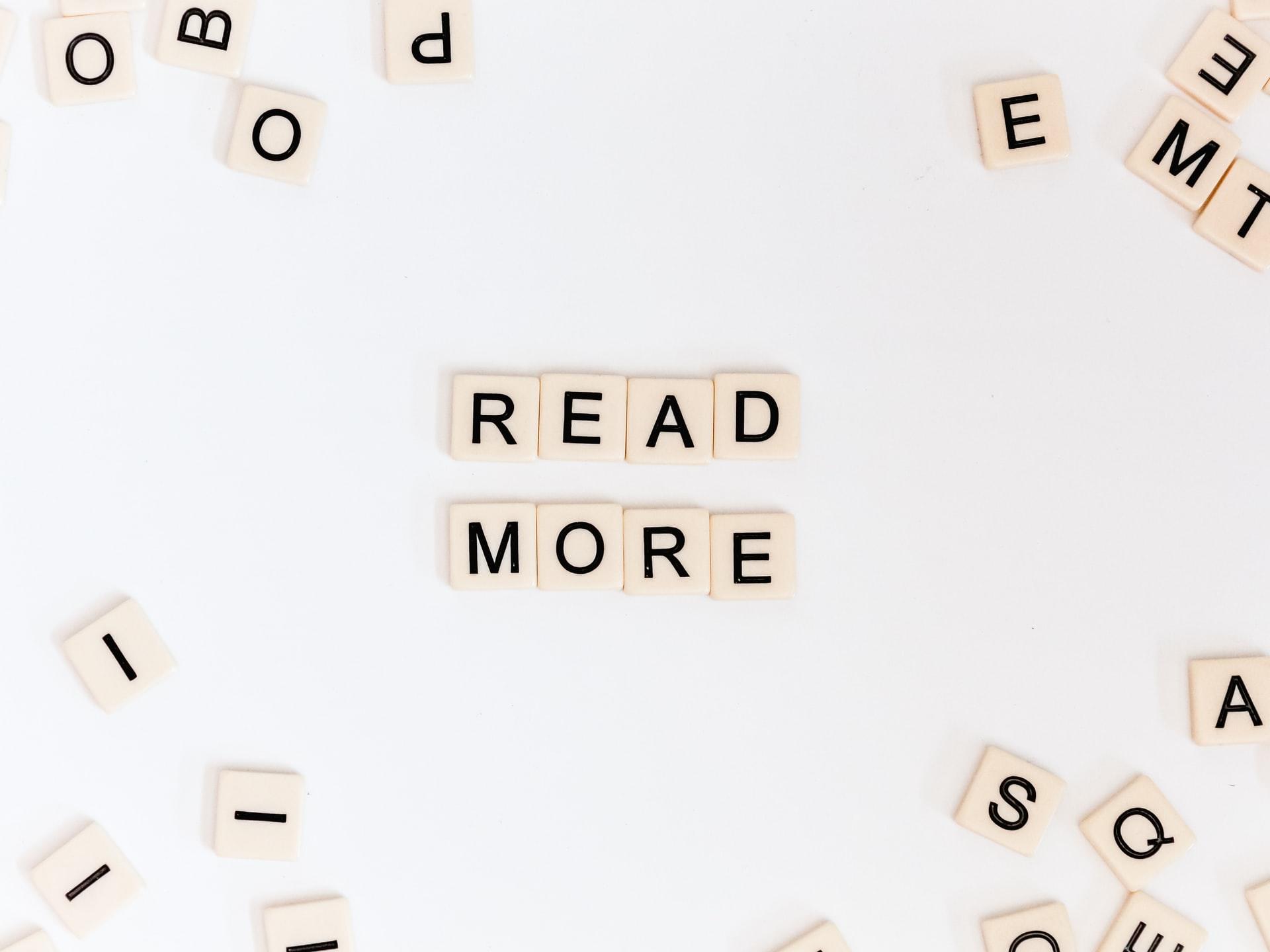 kostki z gry scrabble porozrzucane dookoła i na środku ułożony napis read more