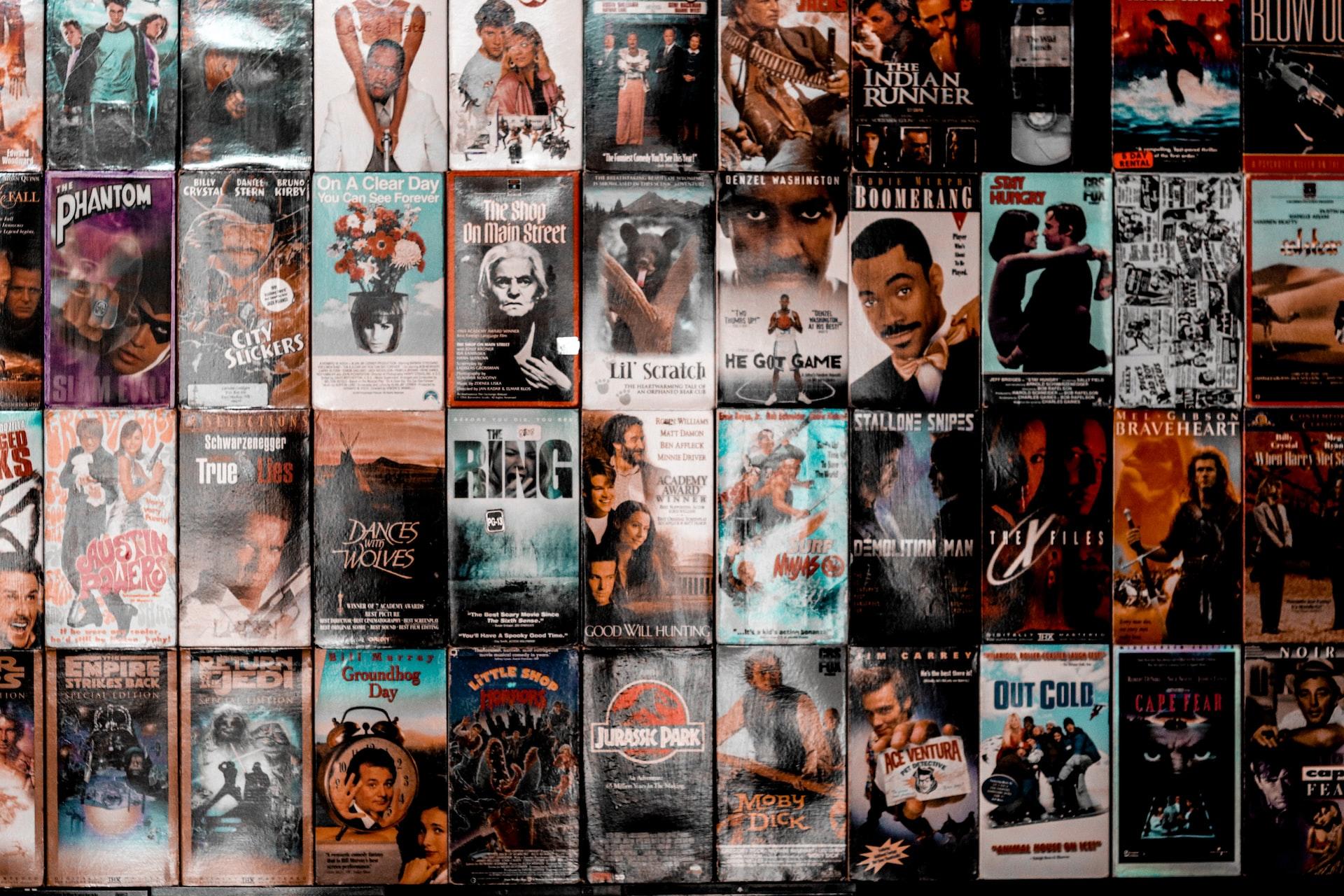 plakaty z okładkami filmów przyklejone na ścianie