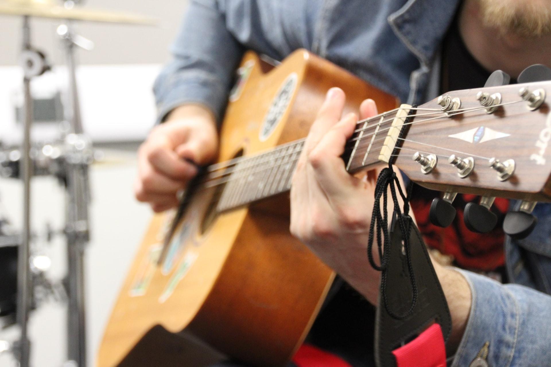 Mężczyzna grający na gitarze akustycznej.