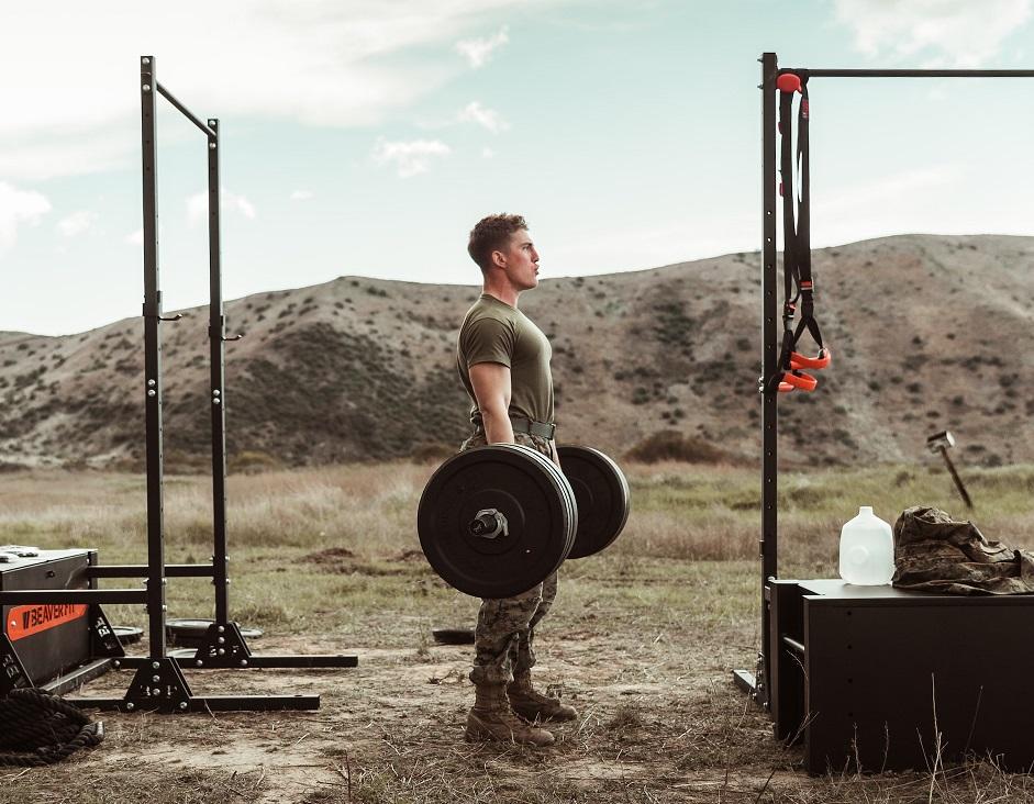 amerykański żołnierz Marine wykonujący martwy ciąg ze sztangą na świeżym powietrzu