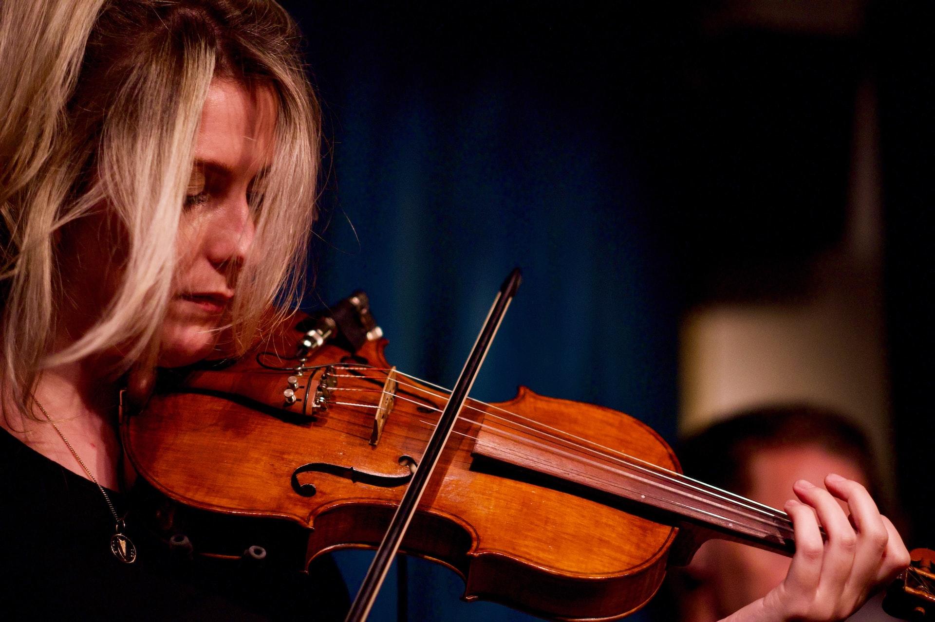 kobieta z jasnymi włosami grająca na skrzypcach