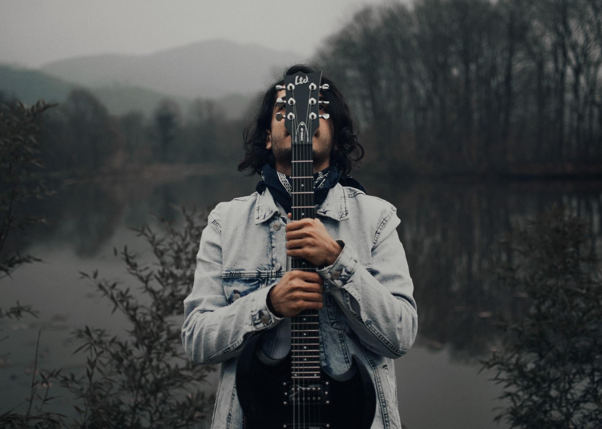 gitara gitarzysta mężczyzna białą kurka ciemny las jezioro woda