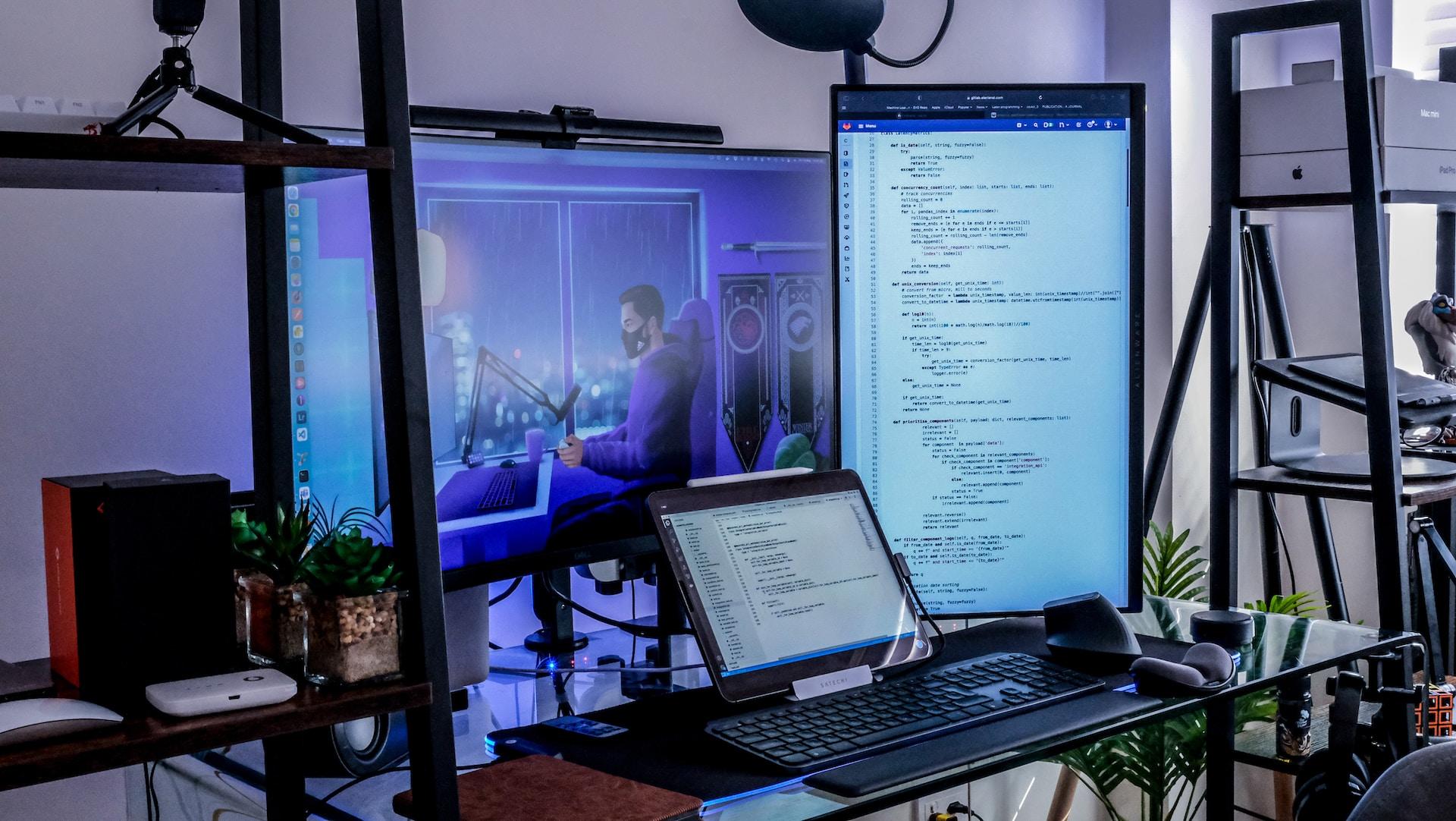 Komputer, monitory na biurku, język programowania komputerowego, Python i Java.