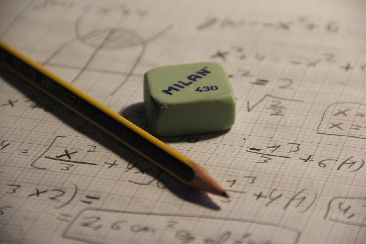Kartka z równaniami matematycznymi, algebra, ołówek, gumka do mazania.