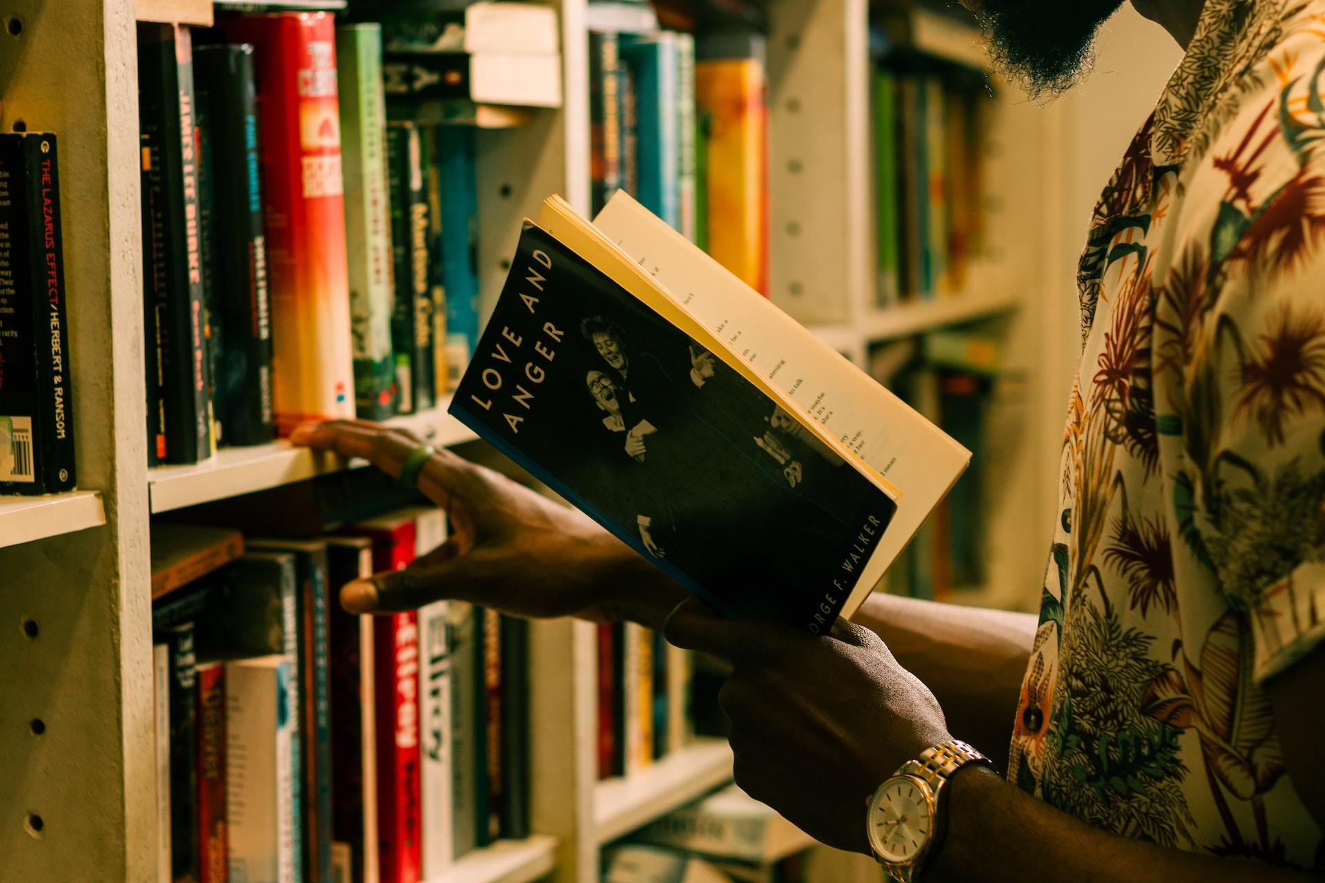 Biblioteka, księgarnia, mężczyzna z książką w ręku, książki.