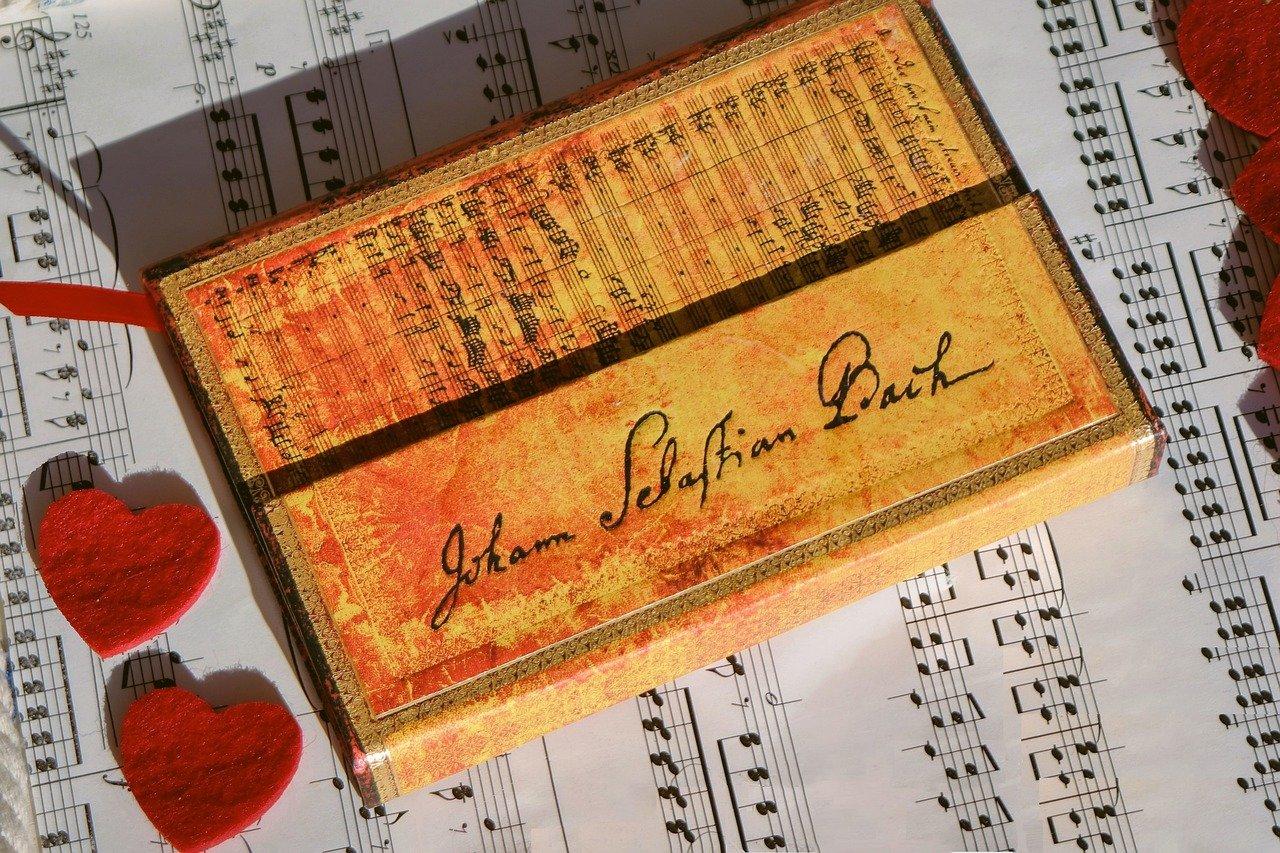 Zapis nutowy, nuty na pianino, czerwone serduszka.