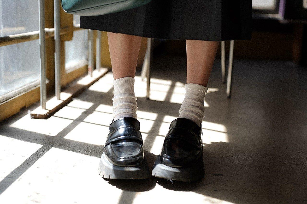 Czarne buty, białe skarpetki, dziewczynka siedząca na krześle, egzamin.