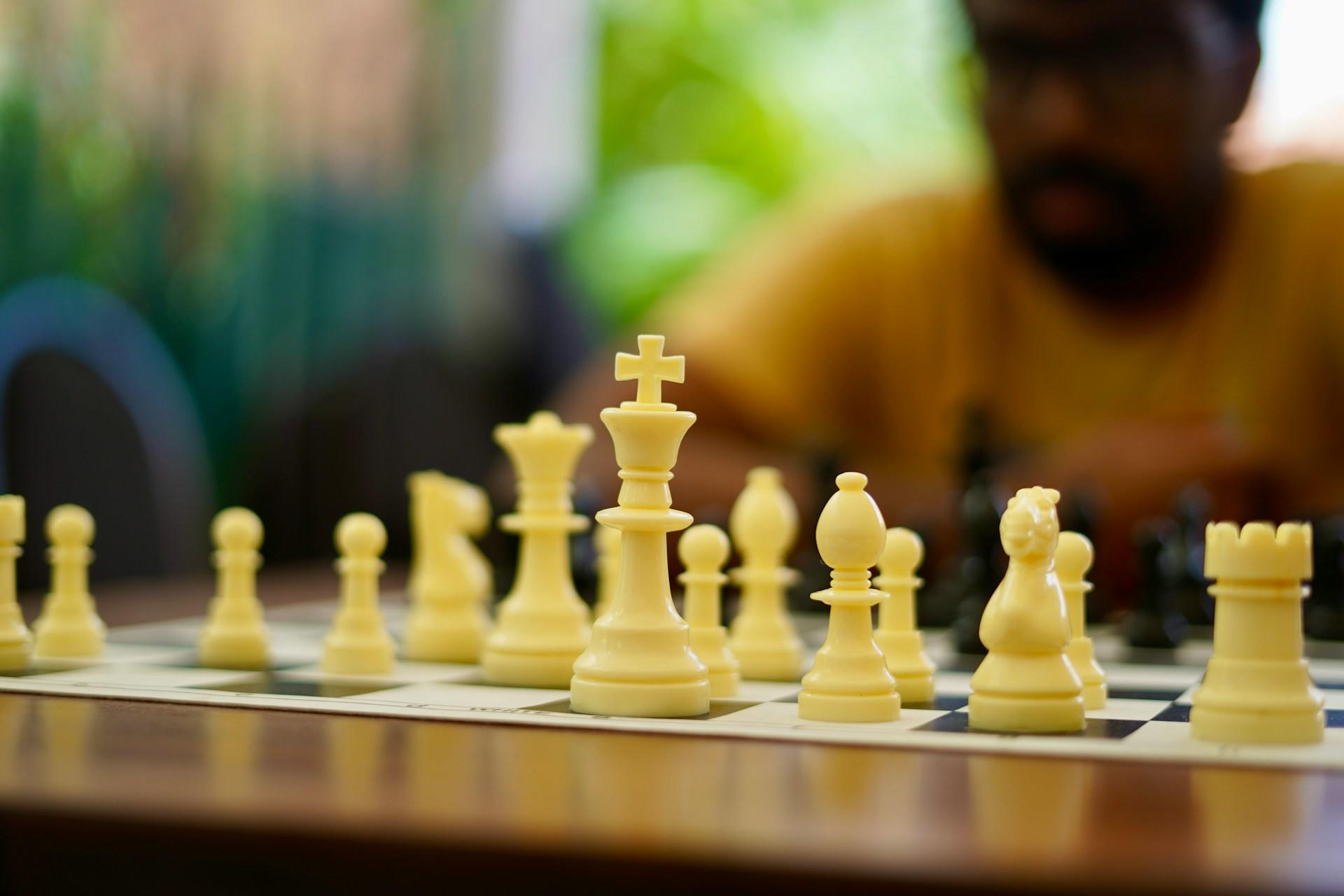 Szachista, szachy, szachownica, białe figury szachowe.