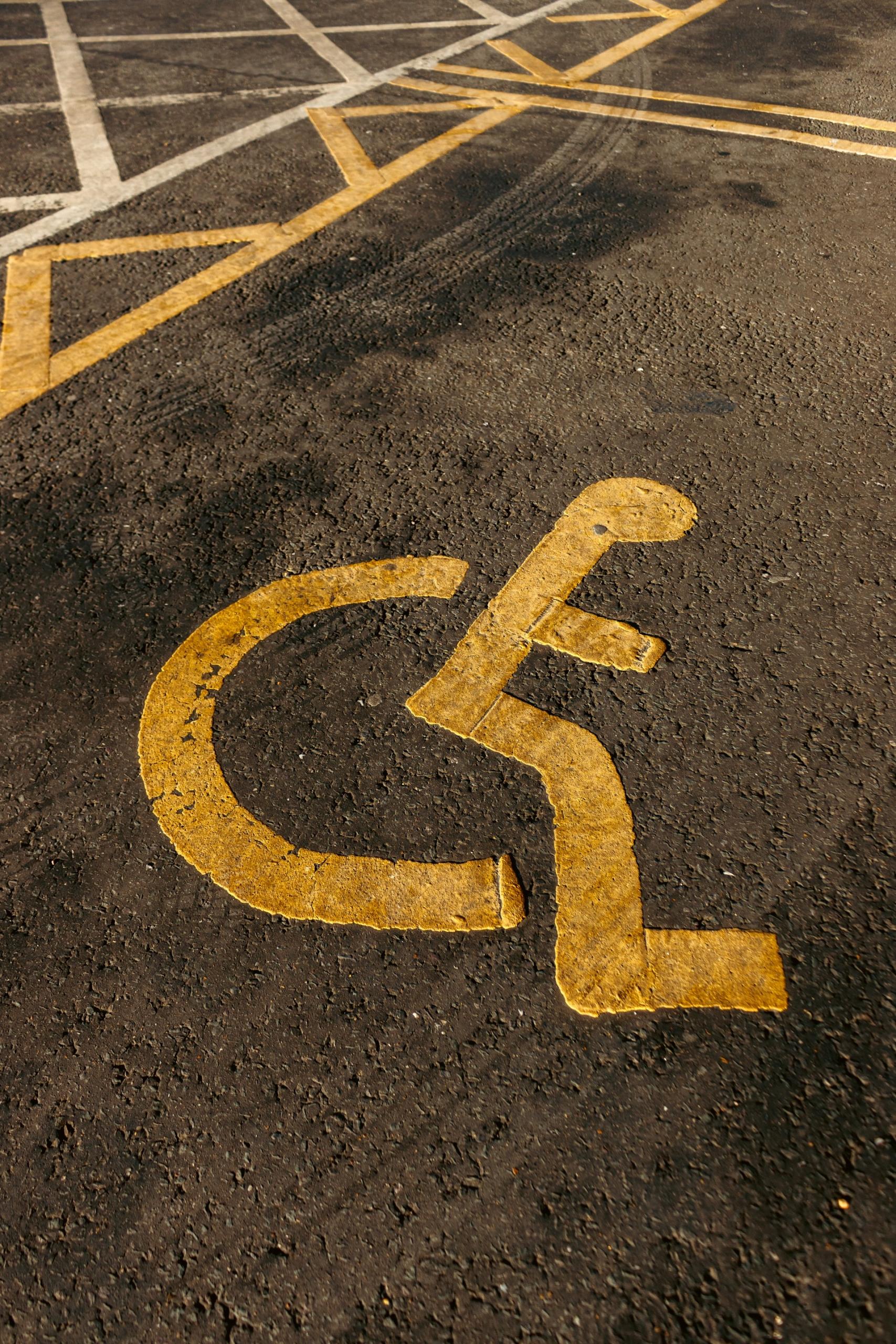Ulica, symbol parkingu dla osób niepełnosprawnych, wózek inwalidzki, człowiek na wózku inwalidzkim, inwalida.