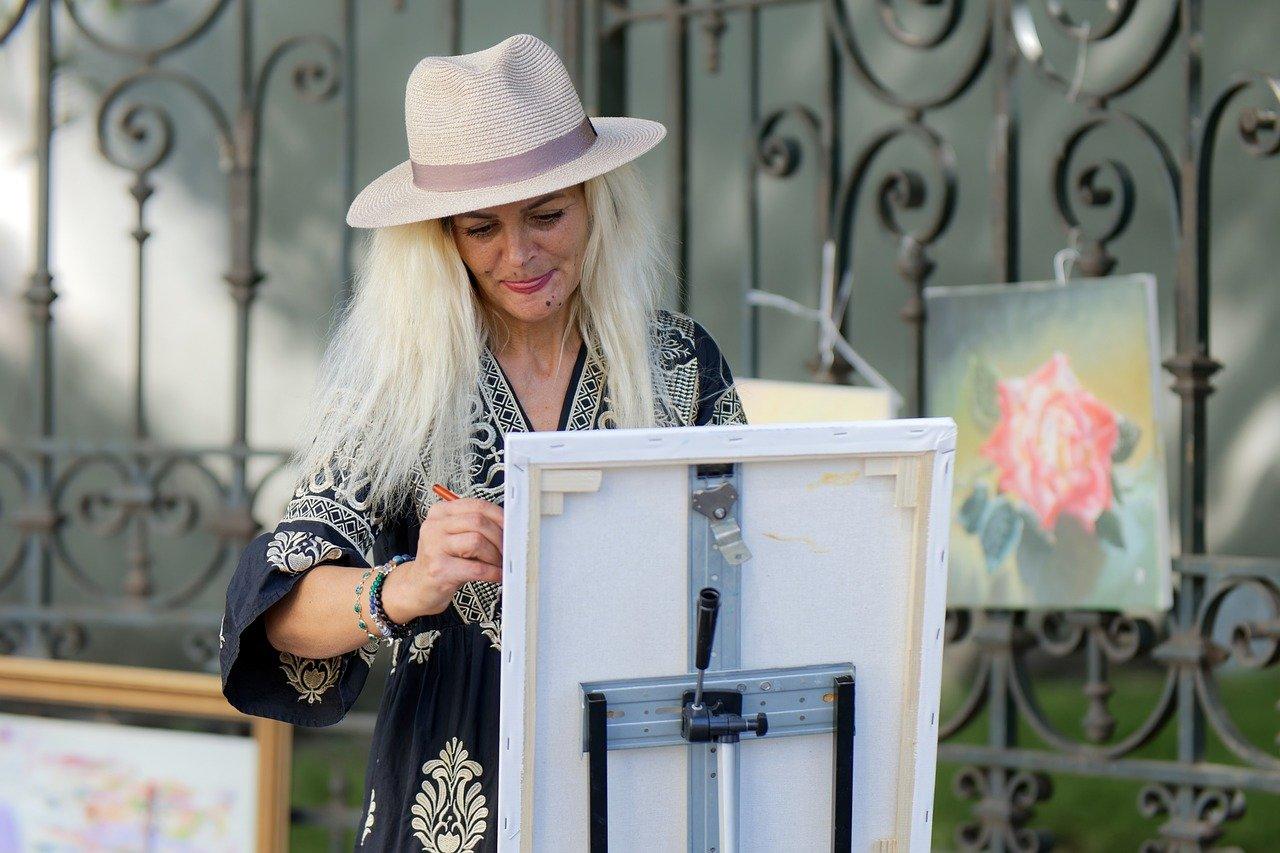 Kobieta w kapeluszu, brama, malarka, obrazy na ulicy, sztaluga, martwa natura.