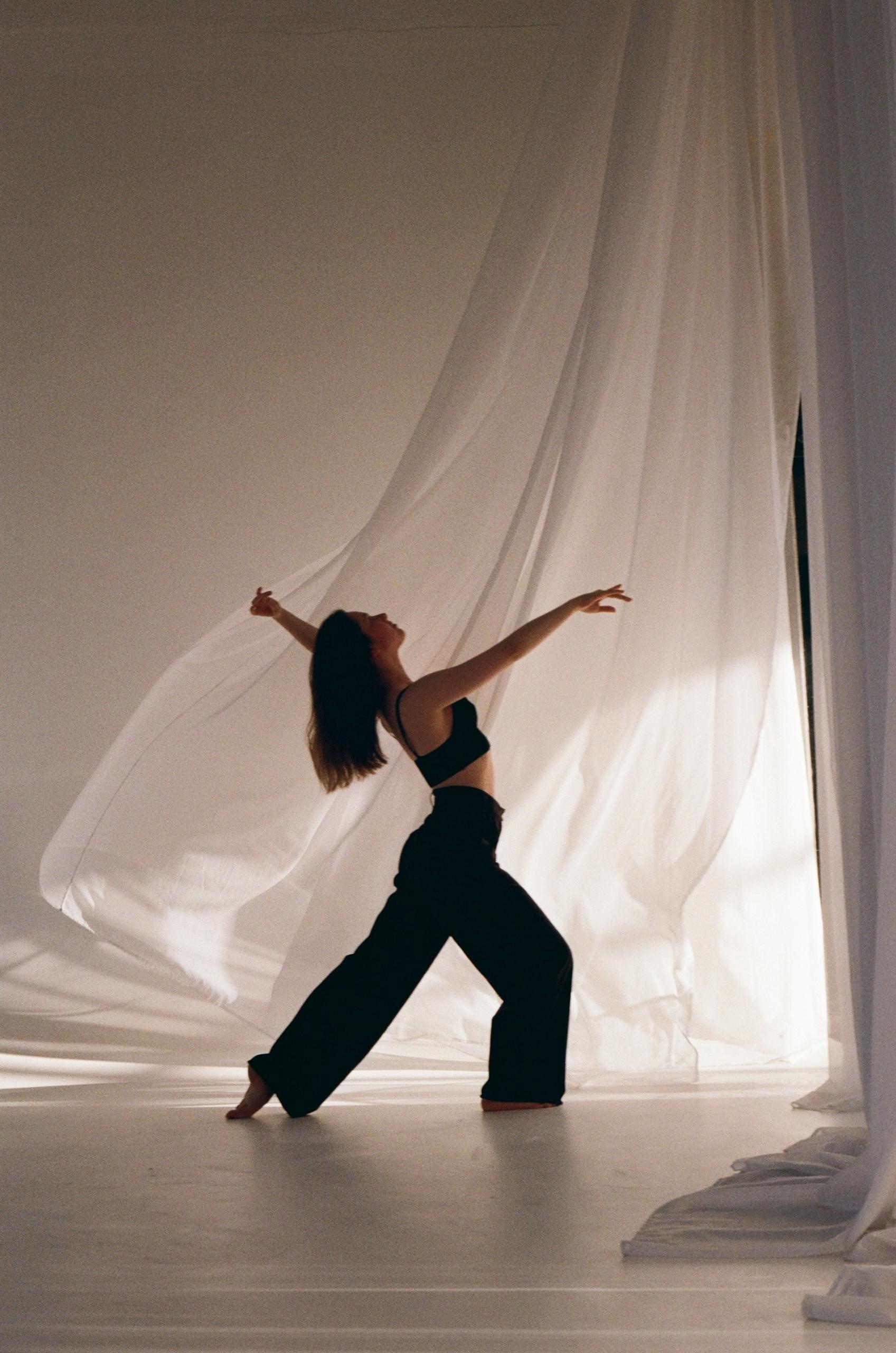 Tancerka, kobieta w czarnych spodniach, taniec, biała zasłona.
