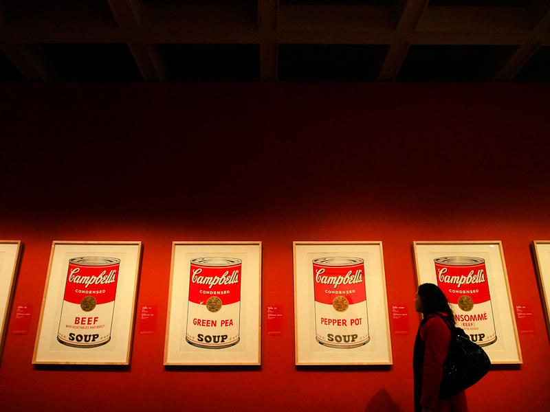 32 puszki z zupą firmy Campbell, Andy Warhol, martwa natura, galeria sztuki, kobieta, obrazy na czerwonej ścianie.