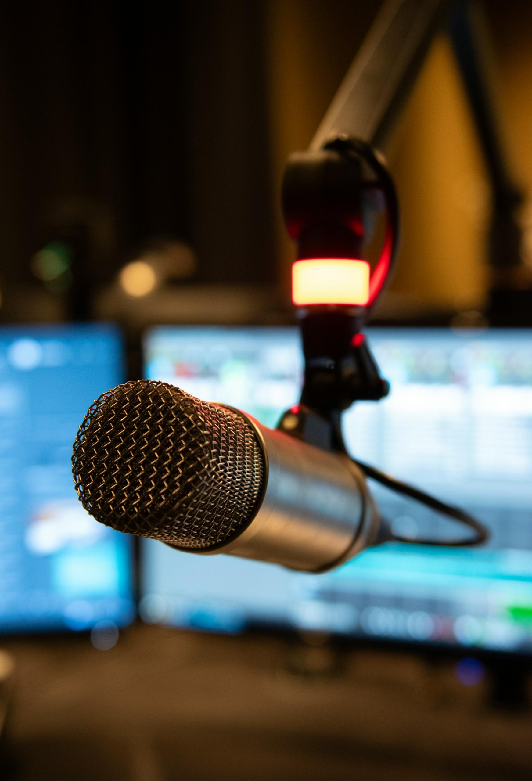 Mikrofon do śpiewania, ekrany komputerów, studio do nagrywania.