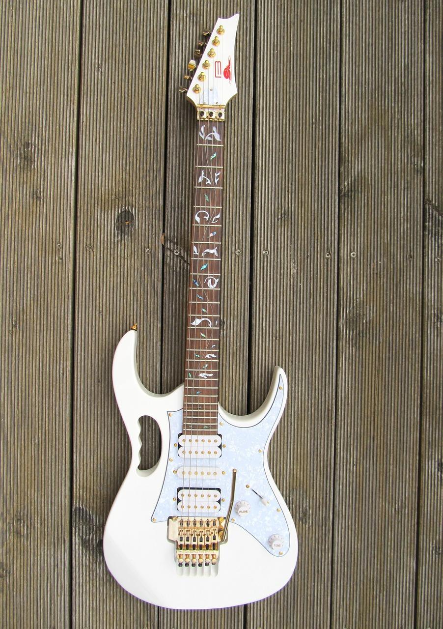  biała gitara elektryczna na drewnianych panelach 