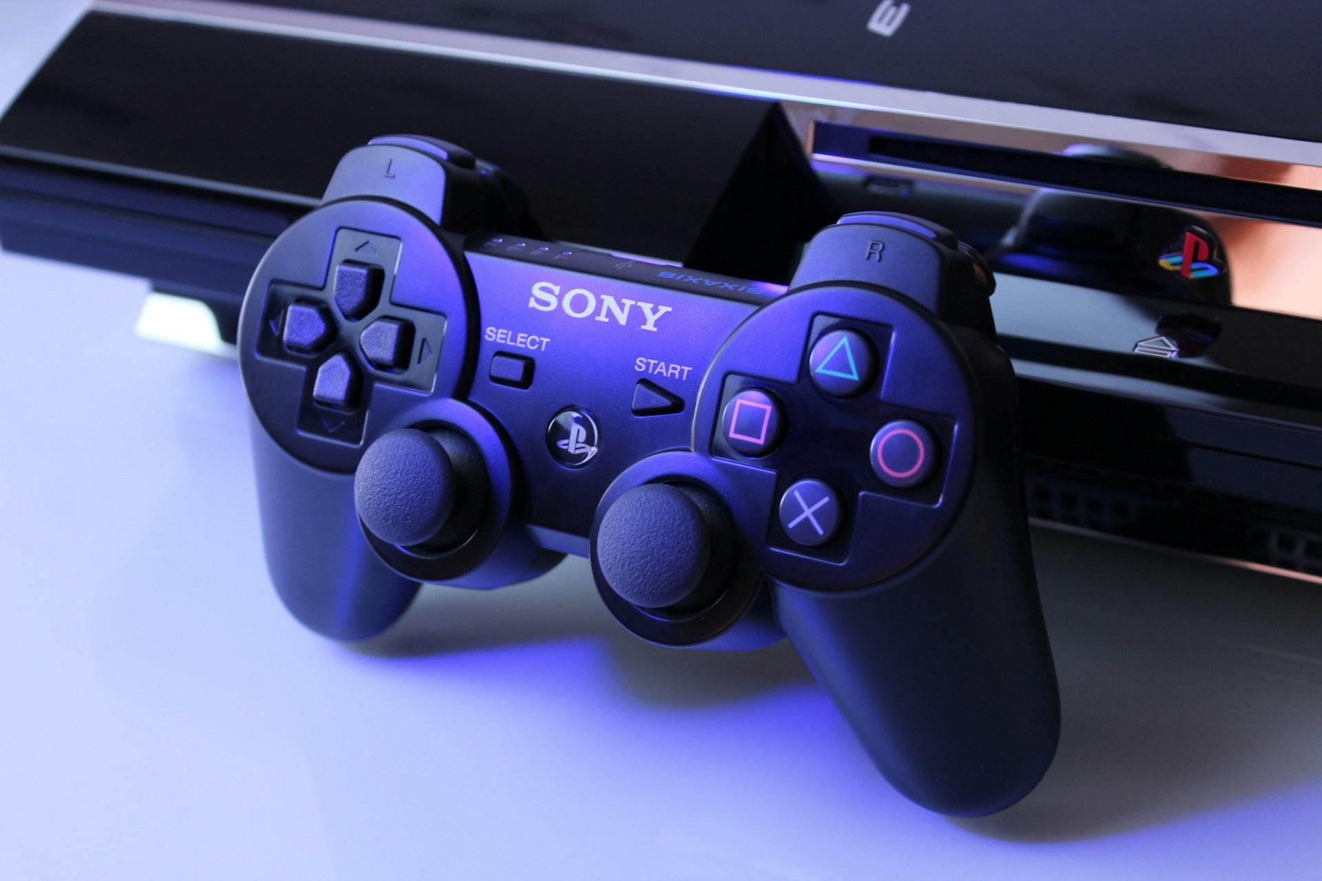 Czarny kontroler i konsola Sony Playstation.