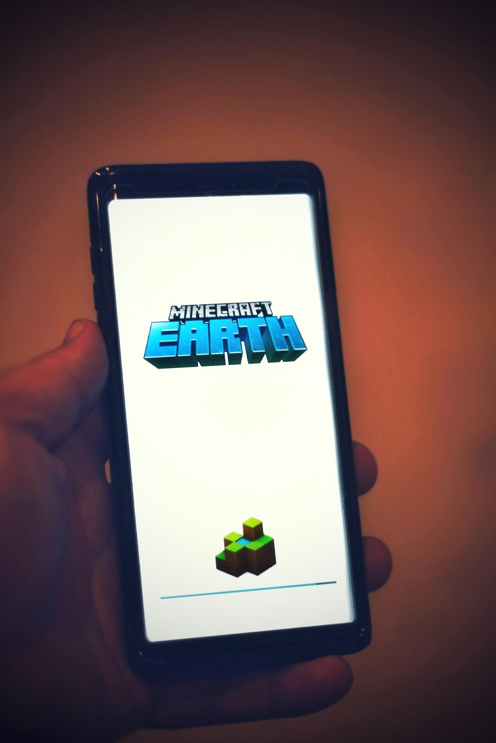 Telefon w dłoni z napisem Minecraft Earth.