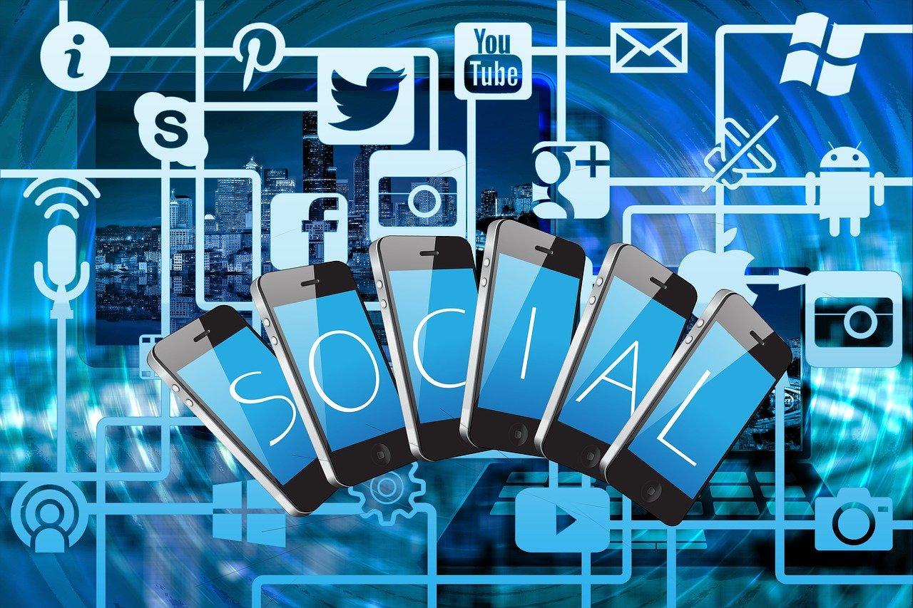 cyfrowy obrazek telefonów z napisem ''social'', ikonki mediów społecznościowych, wszystko w niebieskich tonach