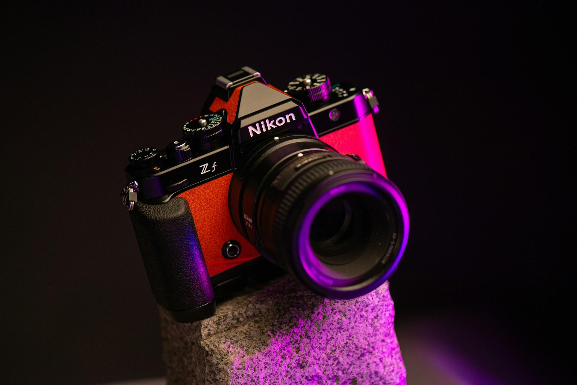 Czerwony aparat fotograficzny Nikon na kamieniu.