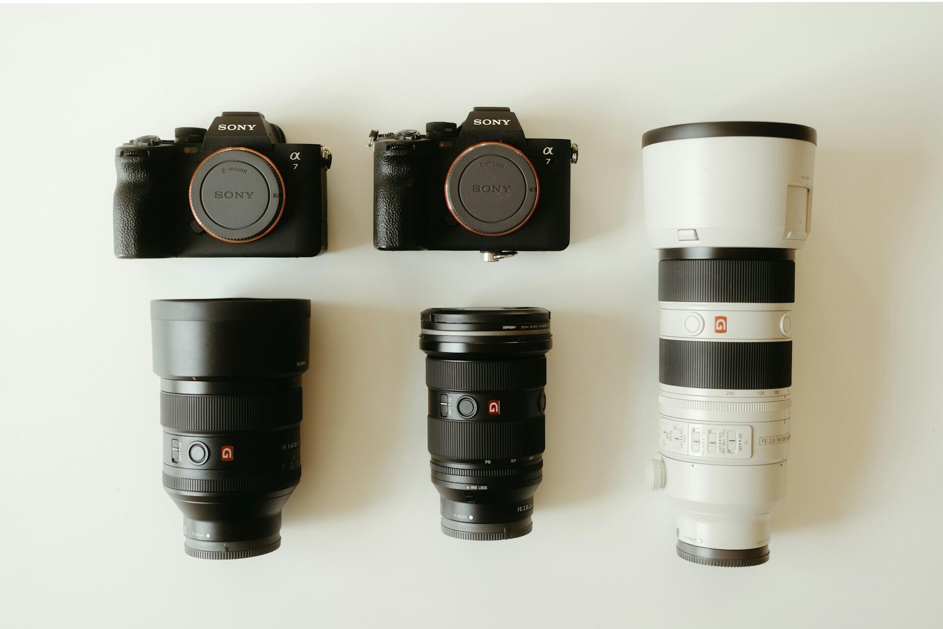 Aparaty fotograficzne Sony i długie obiektywy.