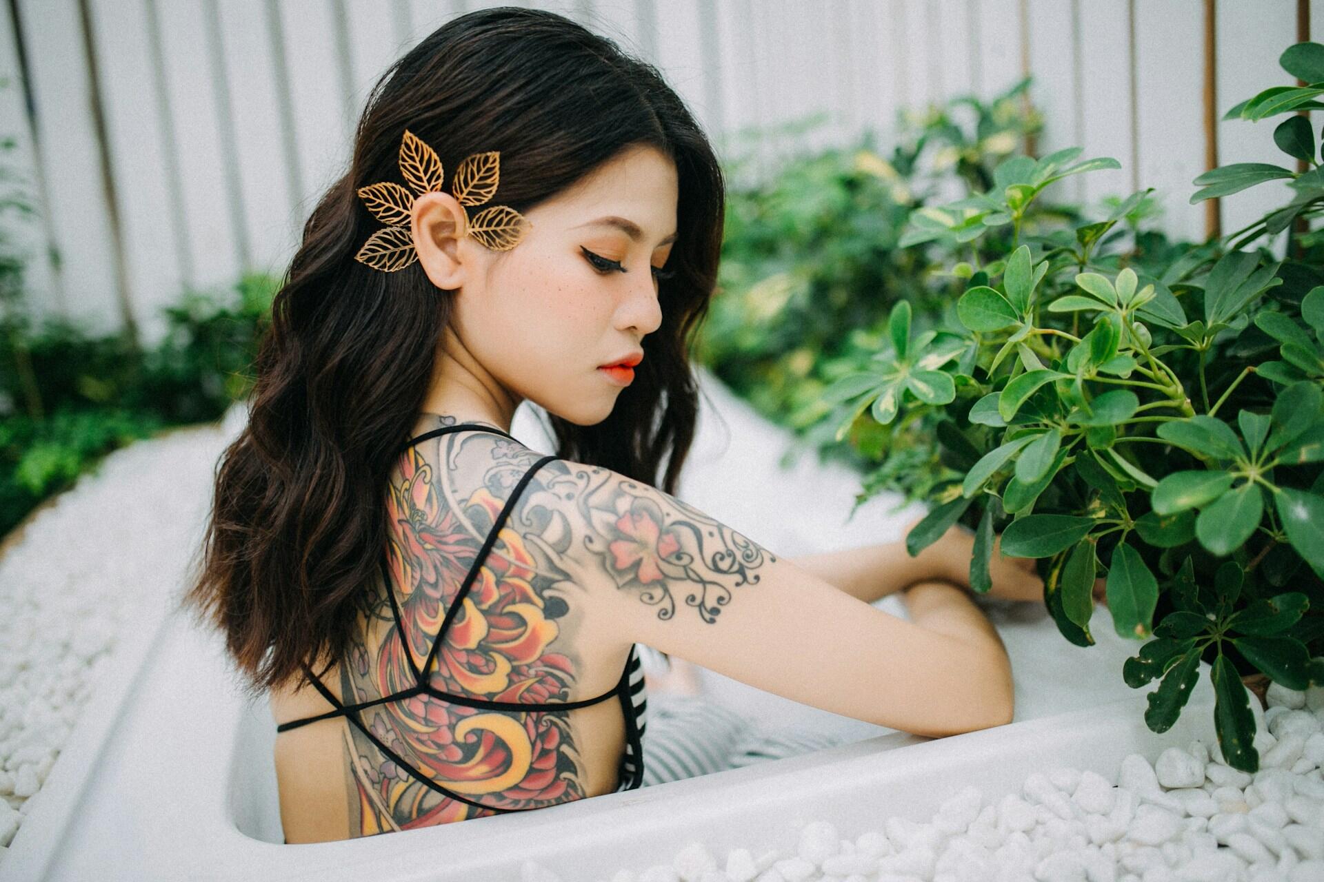 koreanka w wannie w bikini, tatuaże, czarne rozpuszczone włosy