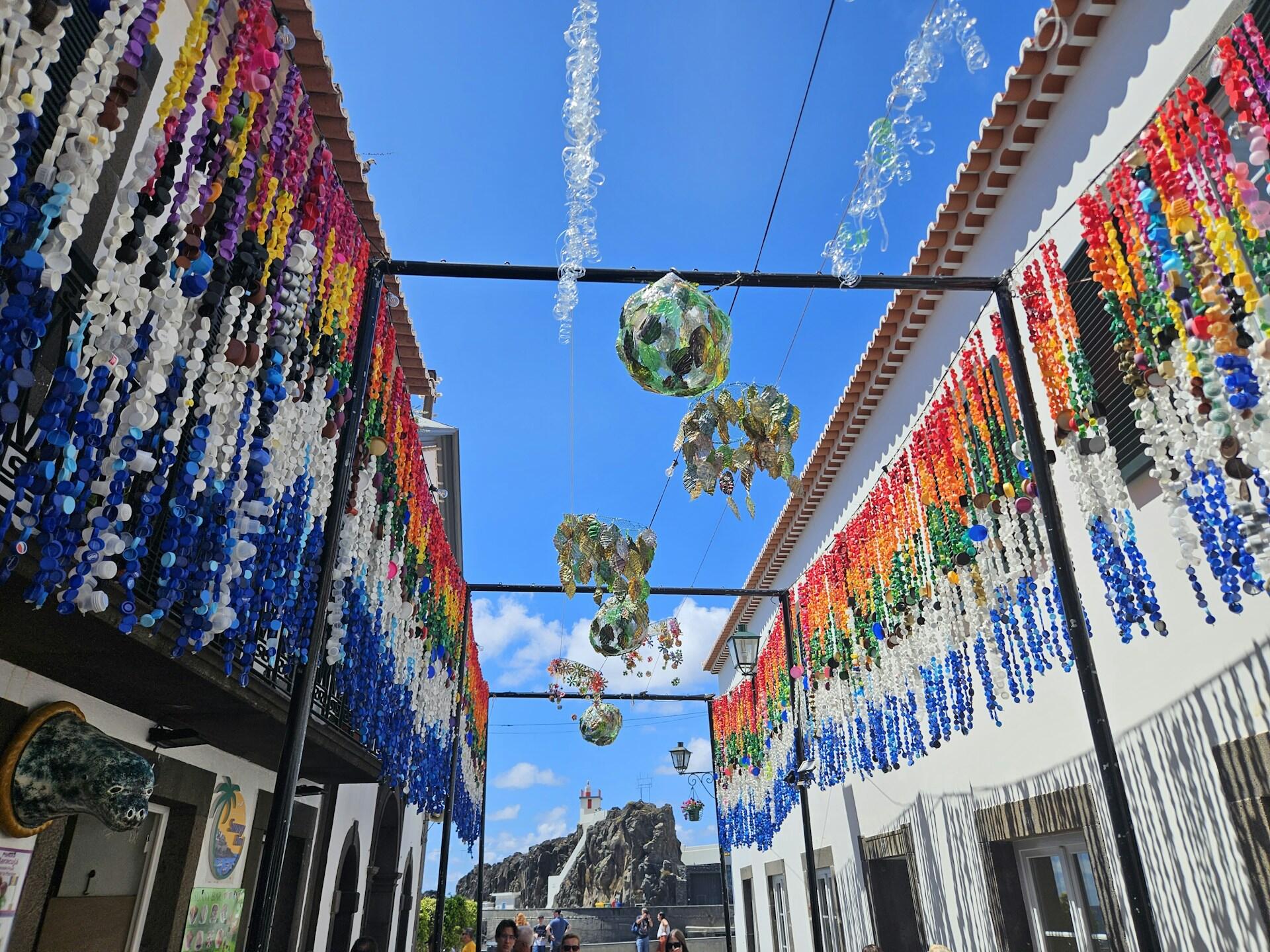 Madeira, Portugalia, ściany obwieszone wieńcami w wąskiej uliczce.