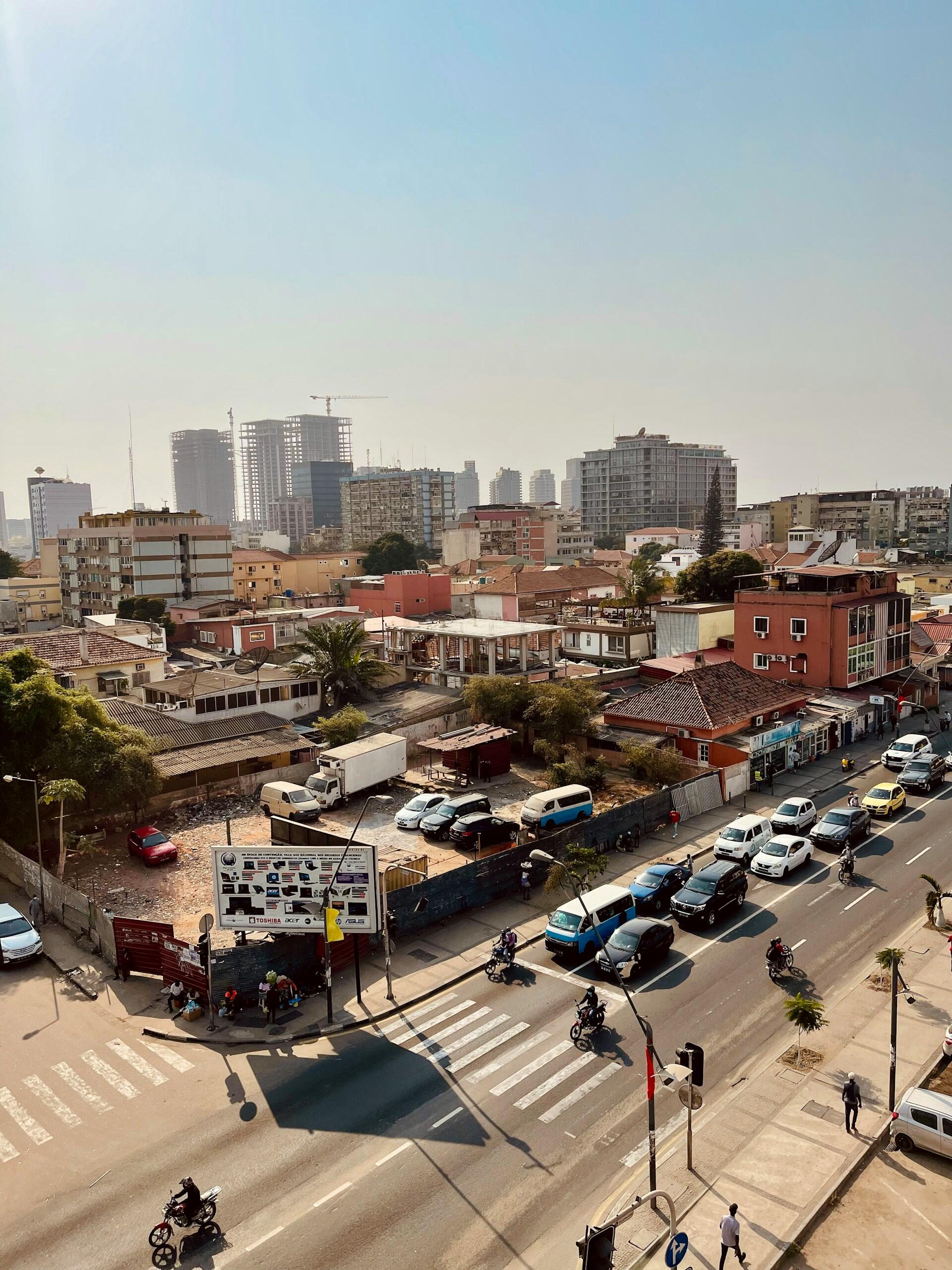 Luanda, Angola, ruch uliczny na miejskiej ulicy z wieżowcami w tle.