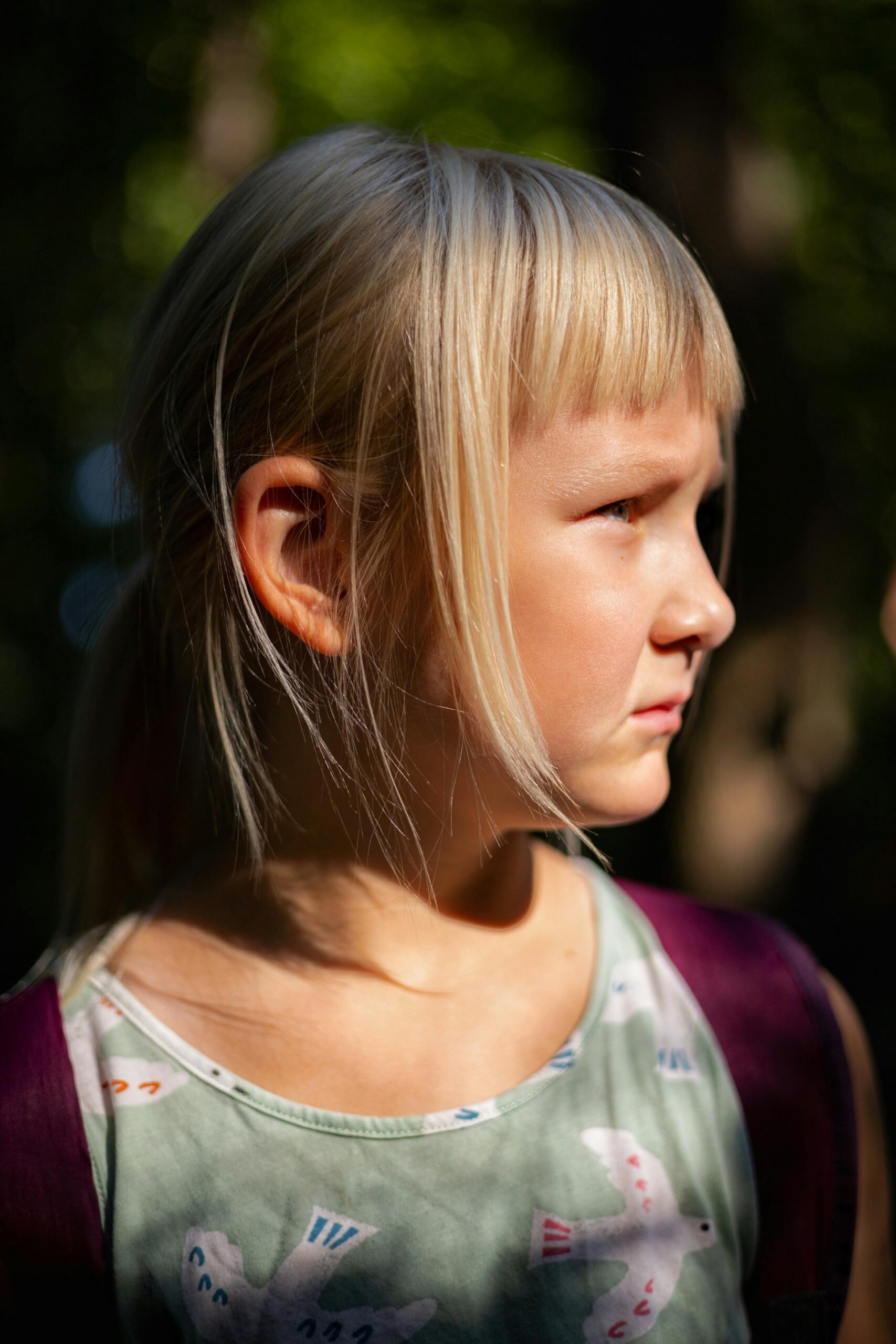 Blond dziewczynka patrząca w bok.