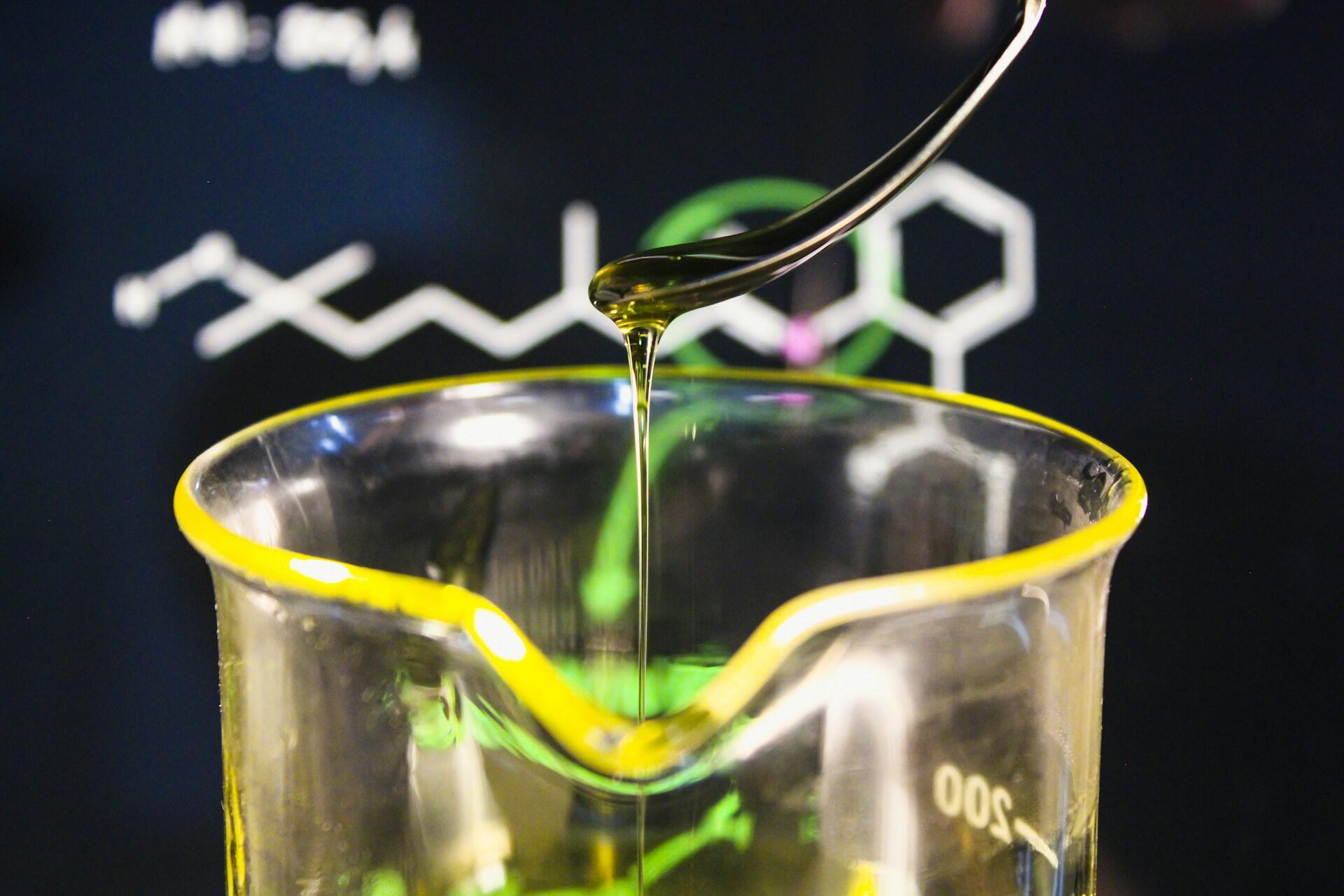 Żółty płyn ściekający do szklanego naczynia chemicznego.