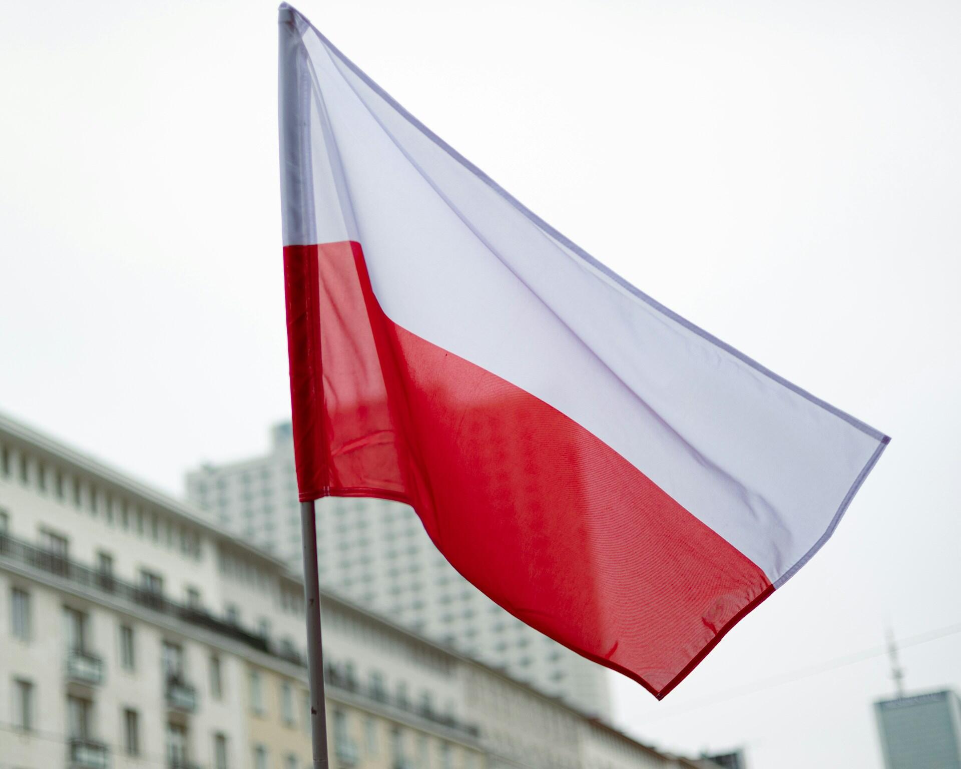 Polska flaga przy budynkach.