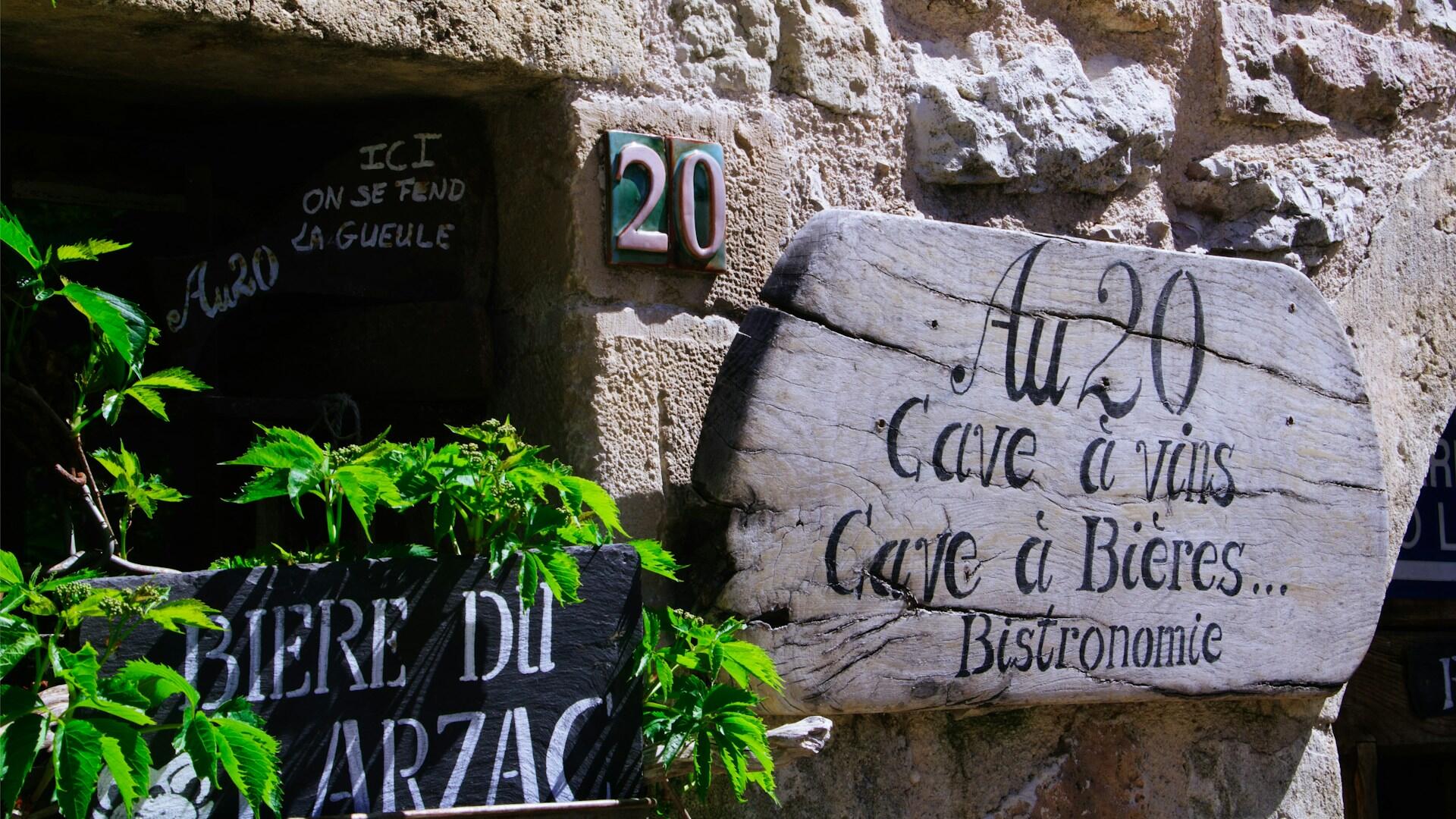 Kamienna tabliczka sklepowa z napisami po francusku.